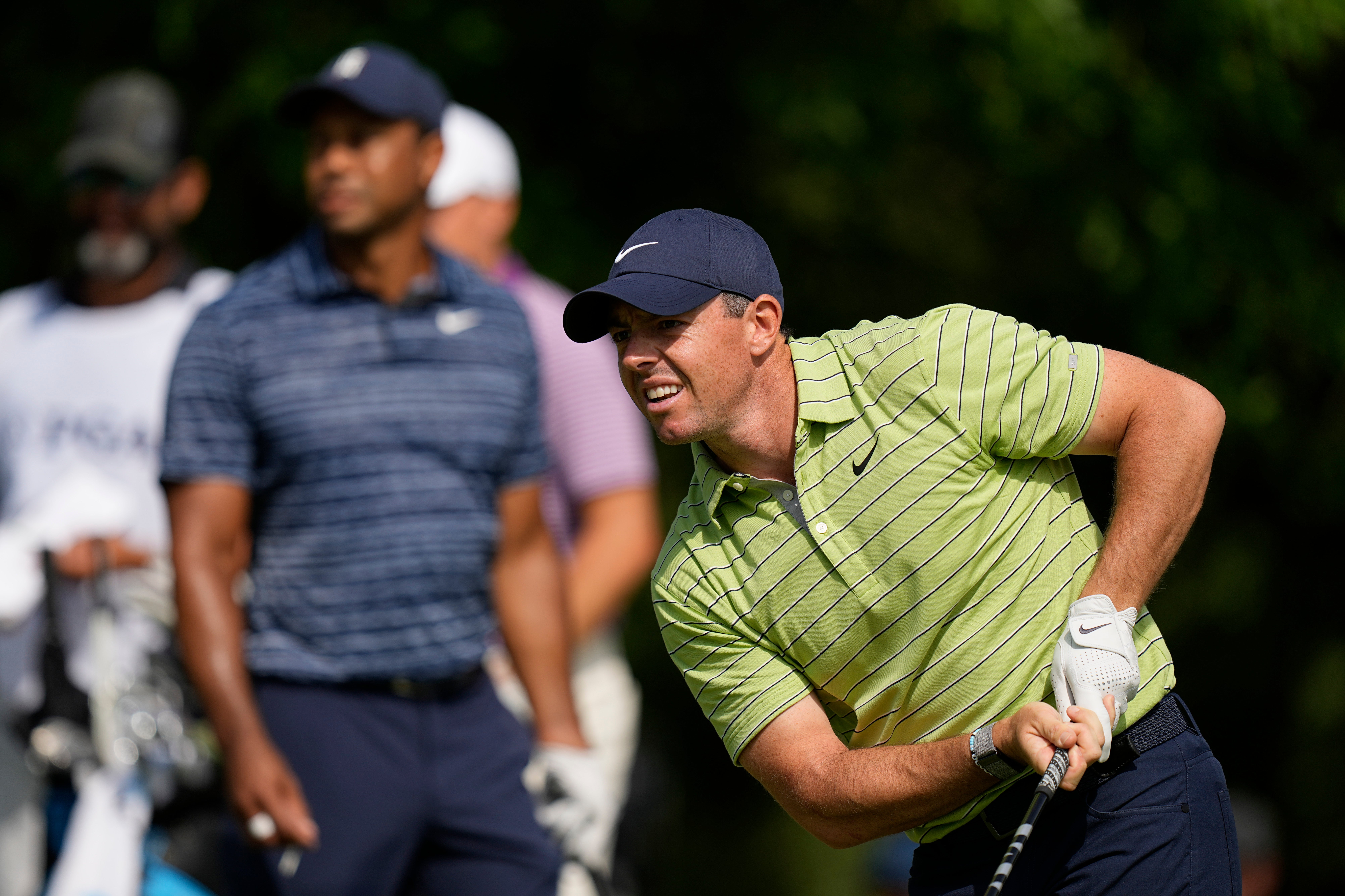 Rory McIlroy watches his tee shot on the 17th hole as Tiger Woods looks on during the first round of the US PGA Championship (Eric Gay/AP)