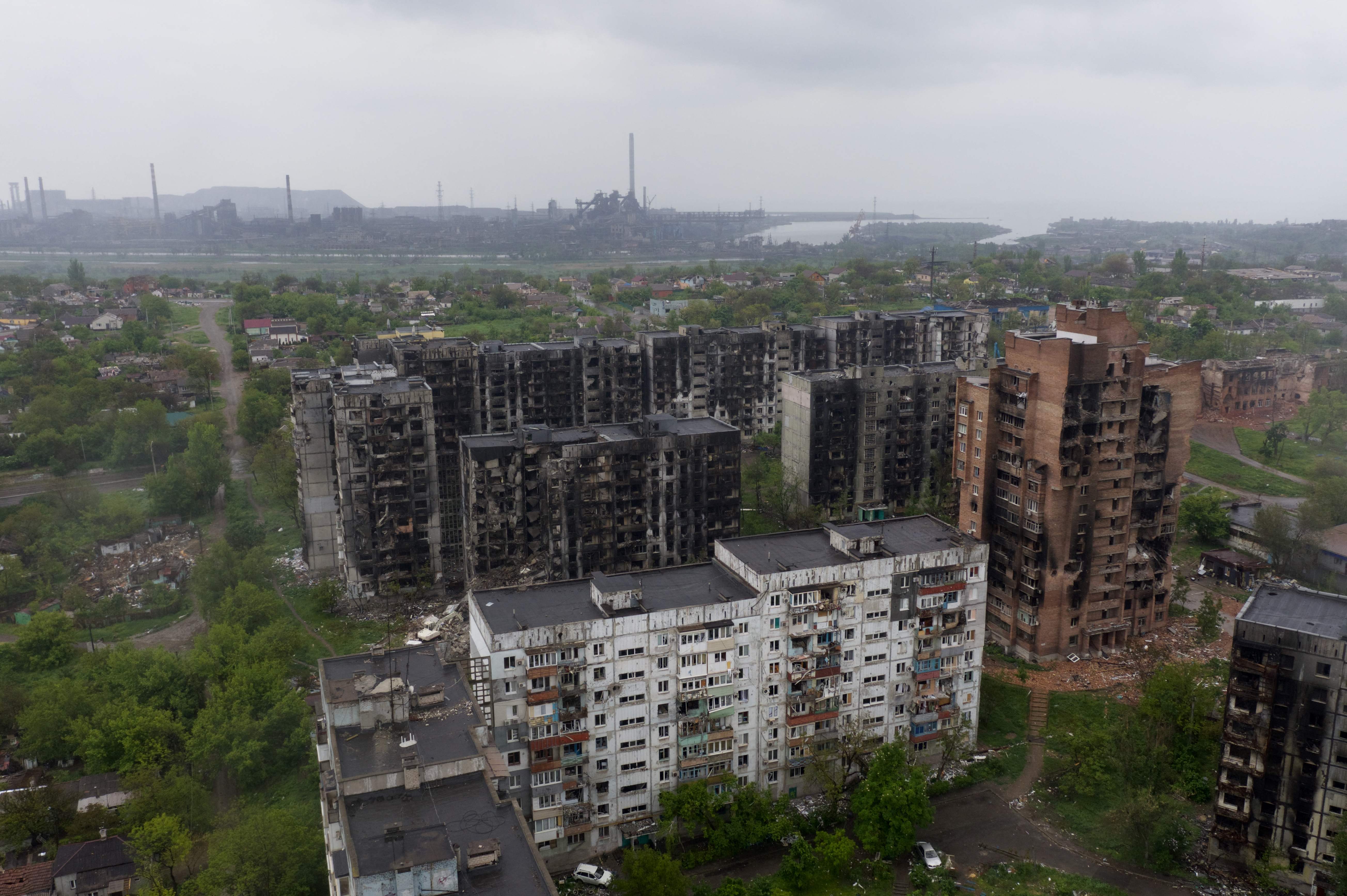 An aerial view of damaged residential buildings and the Azovstal steel plant in the background in the port city of Mariupol