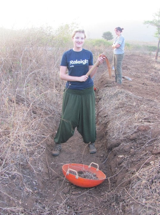 Becky digging a trench to keep elephants off crops at a Raleigh International project in India