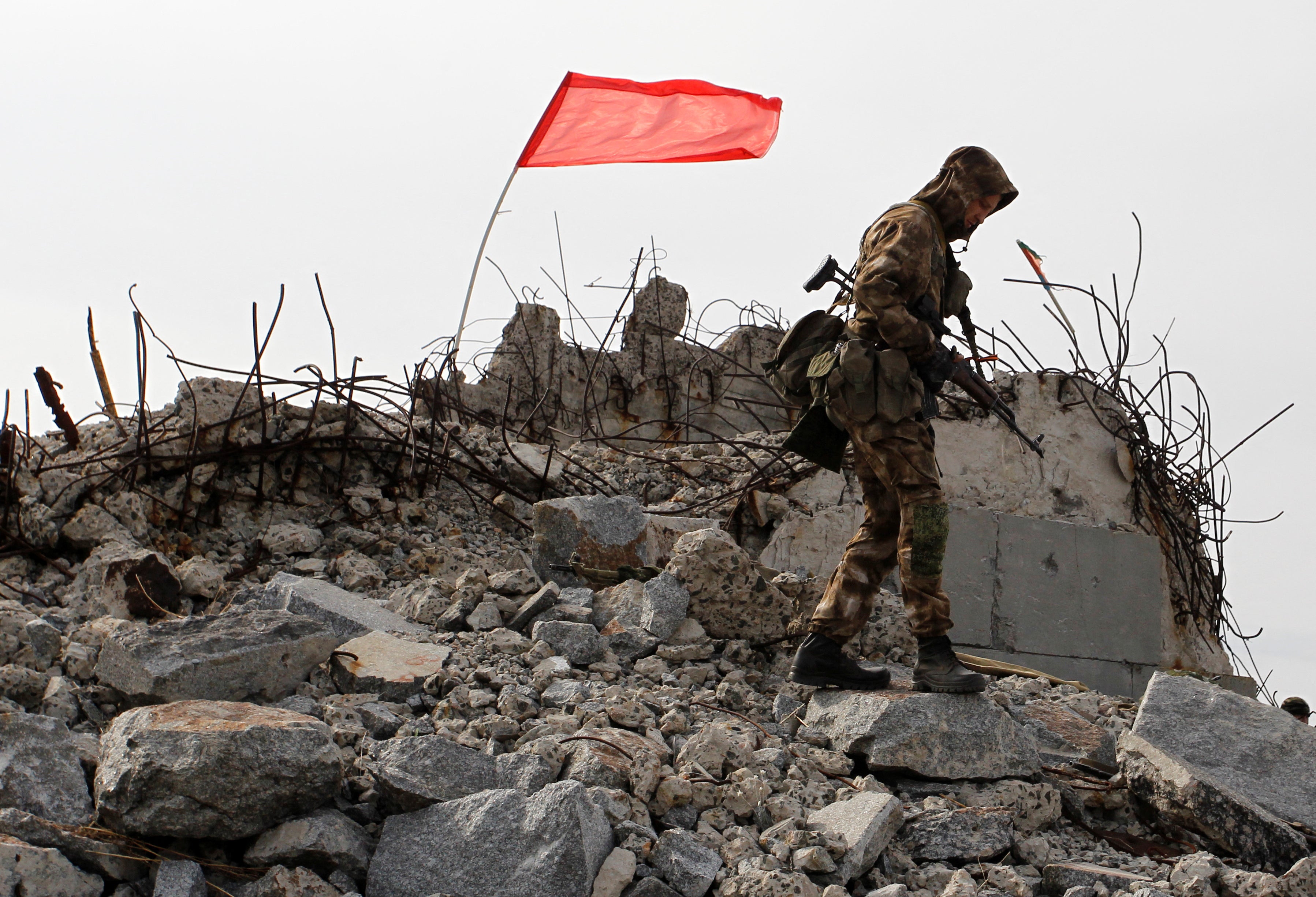 A serviceman of the self-proclaimed Donetsk People’s Republic (DNR) walks at the damaged war memorial complex Savur-Mohyla