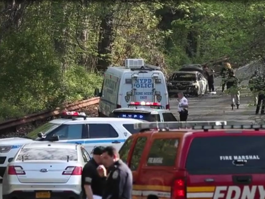 Police officers near the site in Bronx where the burnt car was found on Monday, 16 May 2022