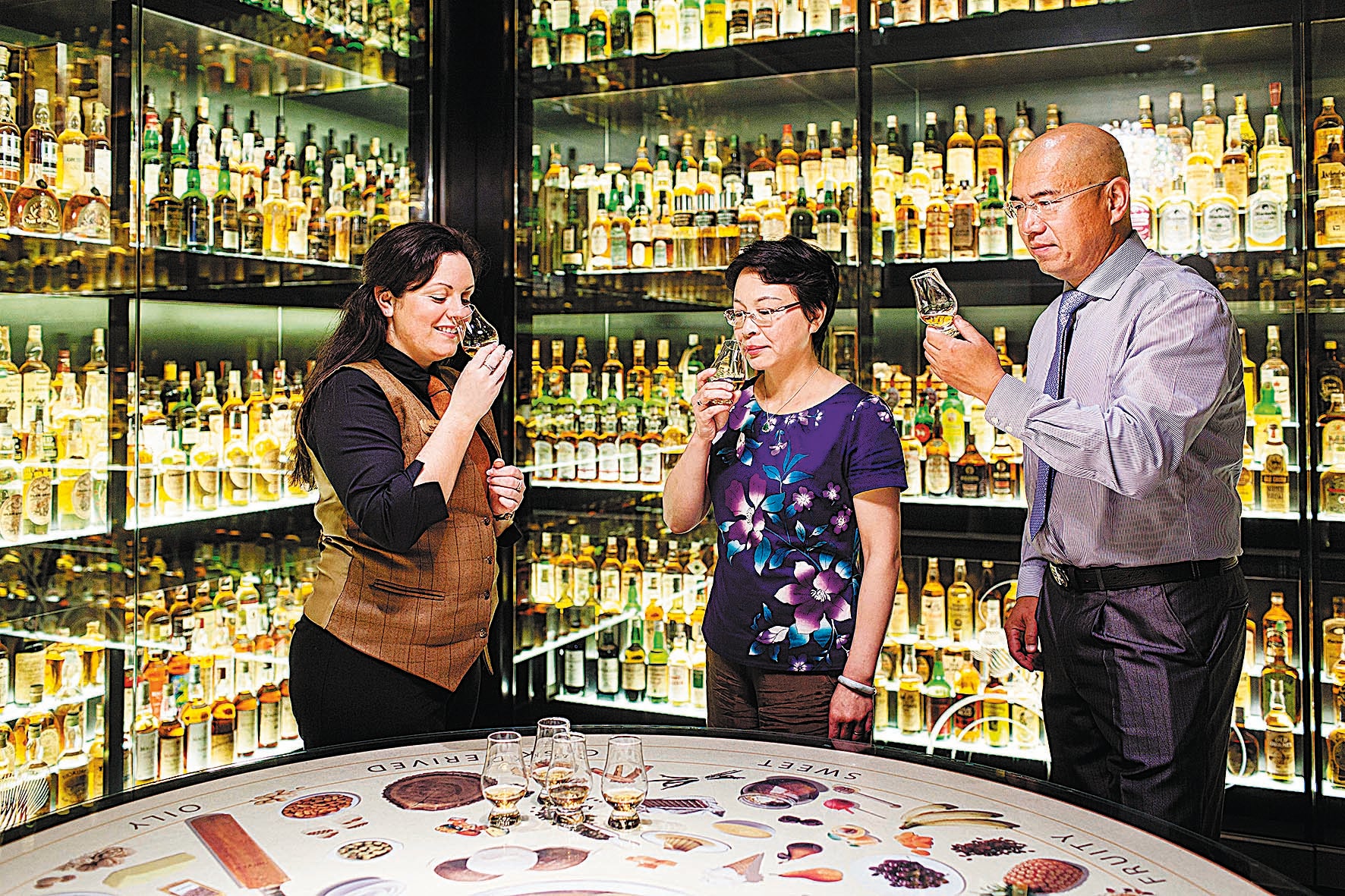 Tourists attend a whisky tasting event in Scotland