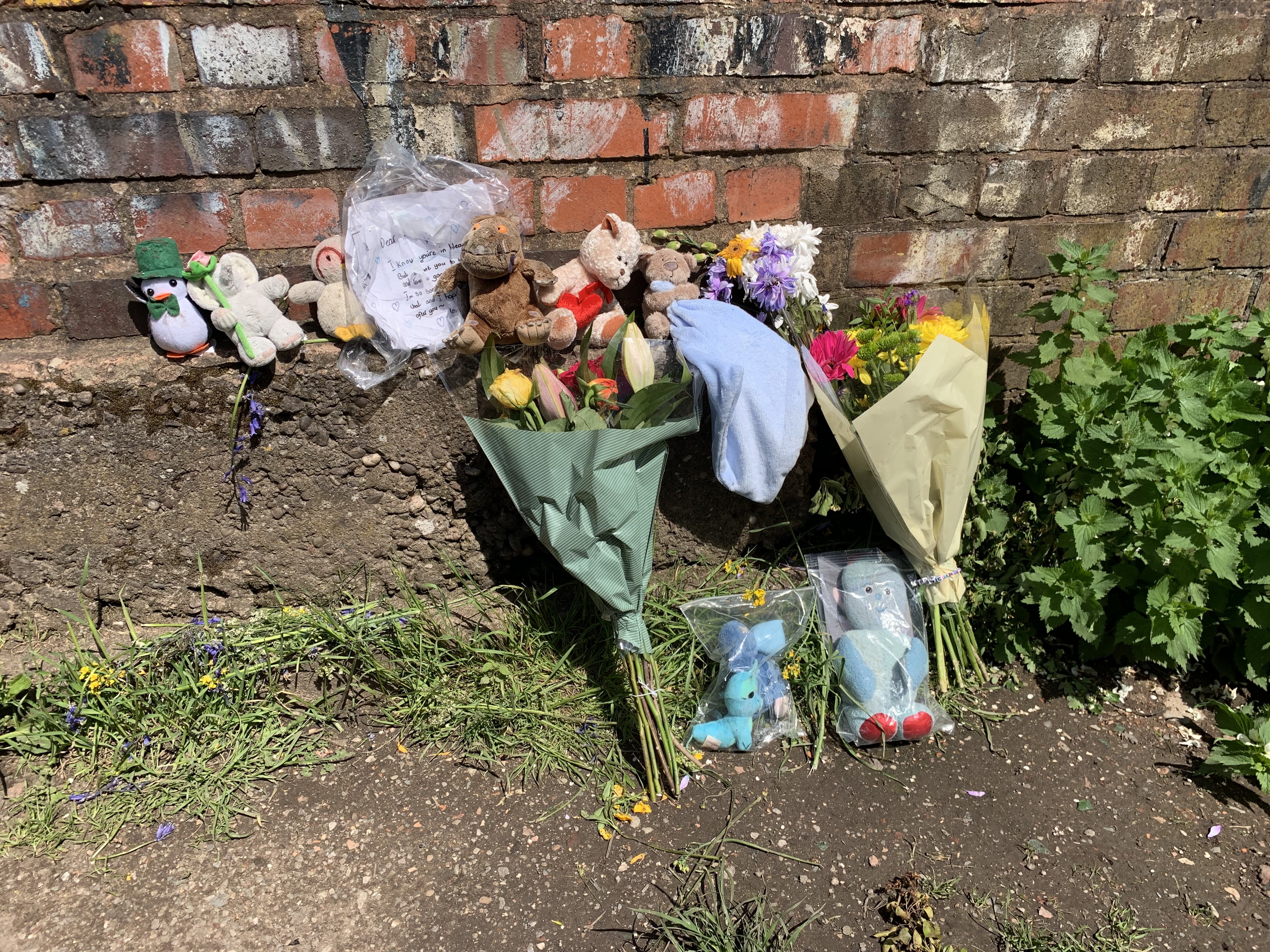 Floral tributes left near Rough Wood country park in Walsall, where a dead newborn boy was found in the local canal (PA)