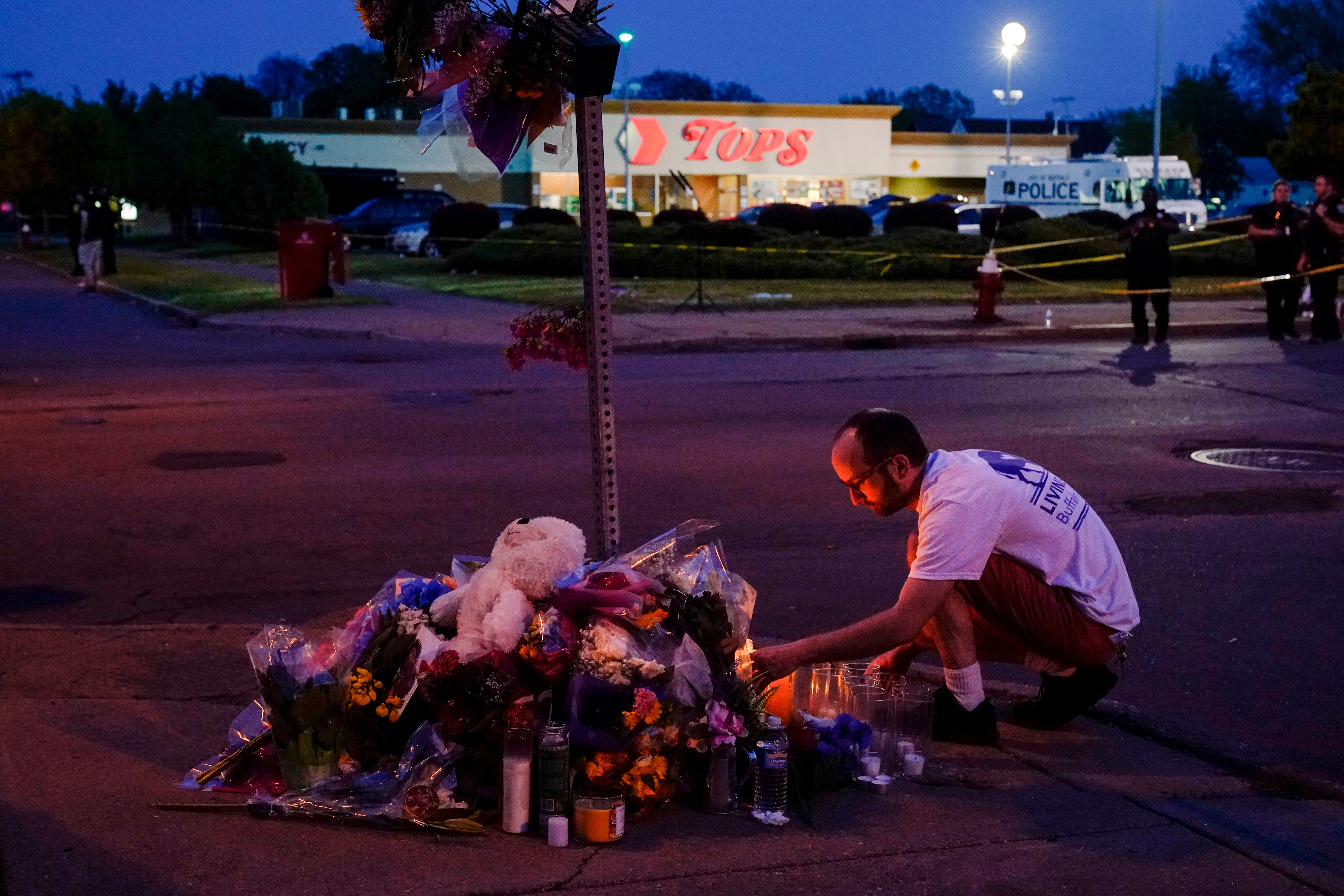 A person pays his respects at a makeshift memorial outside the Tops grocery store