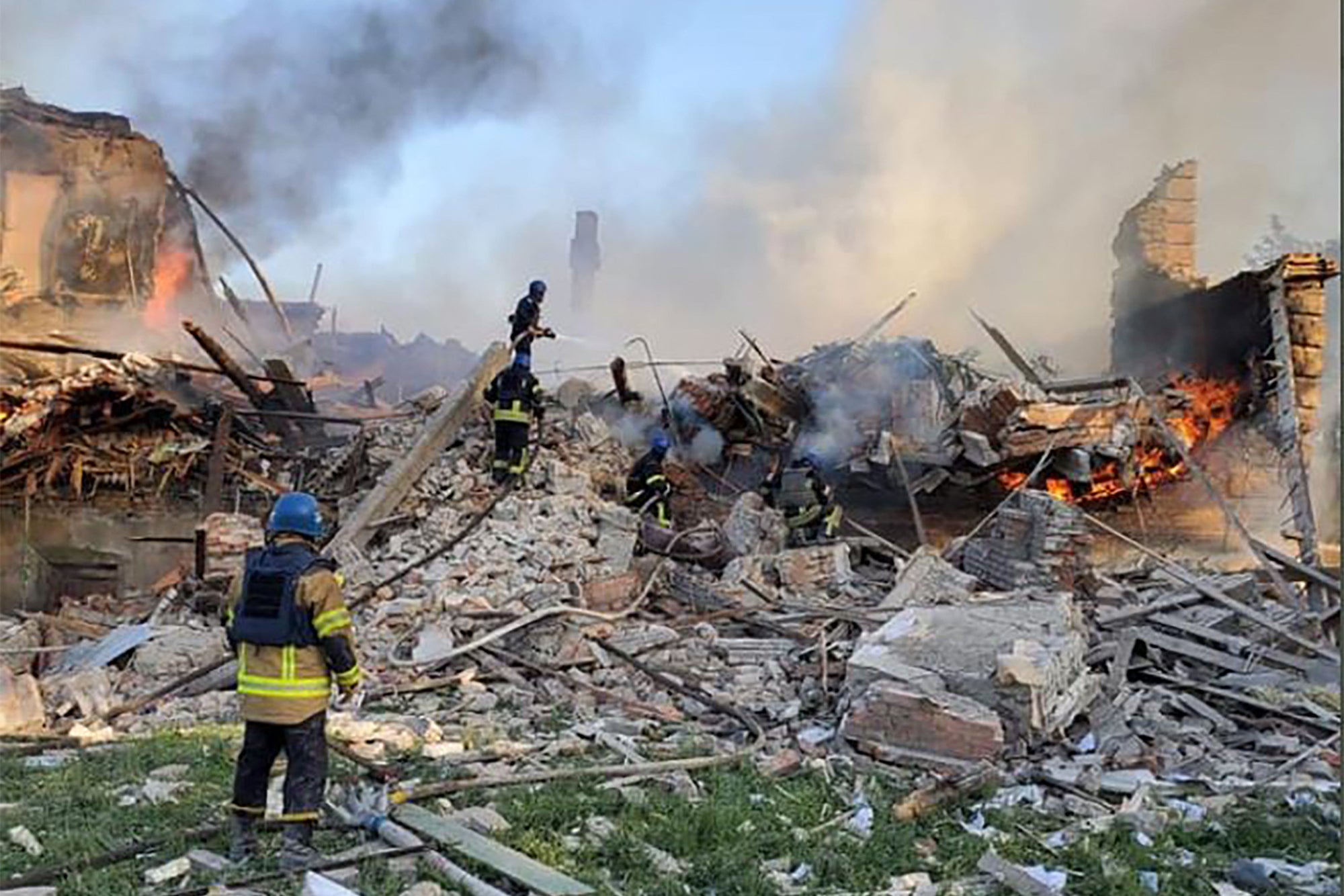 Ukrainian firefighters put out a fire after Russian missiles hit a school in eastern Ukraine’s Luhansk region