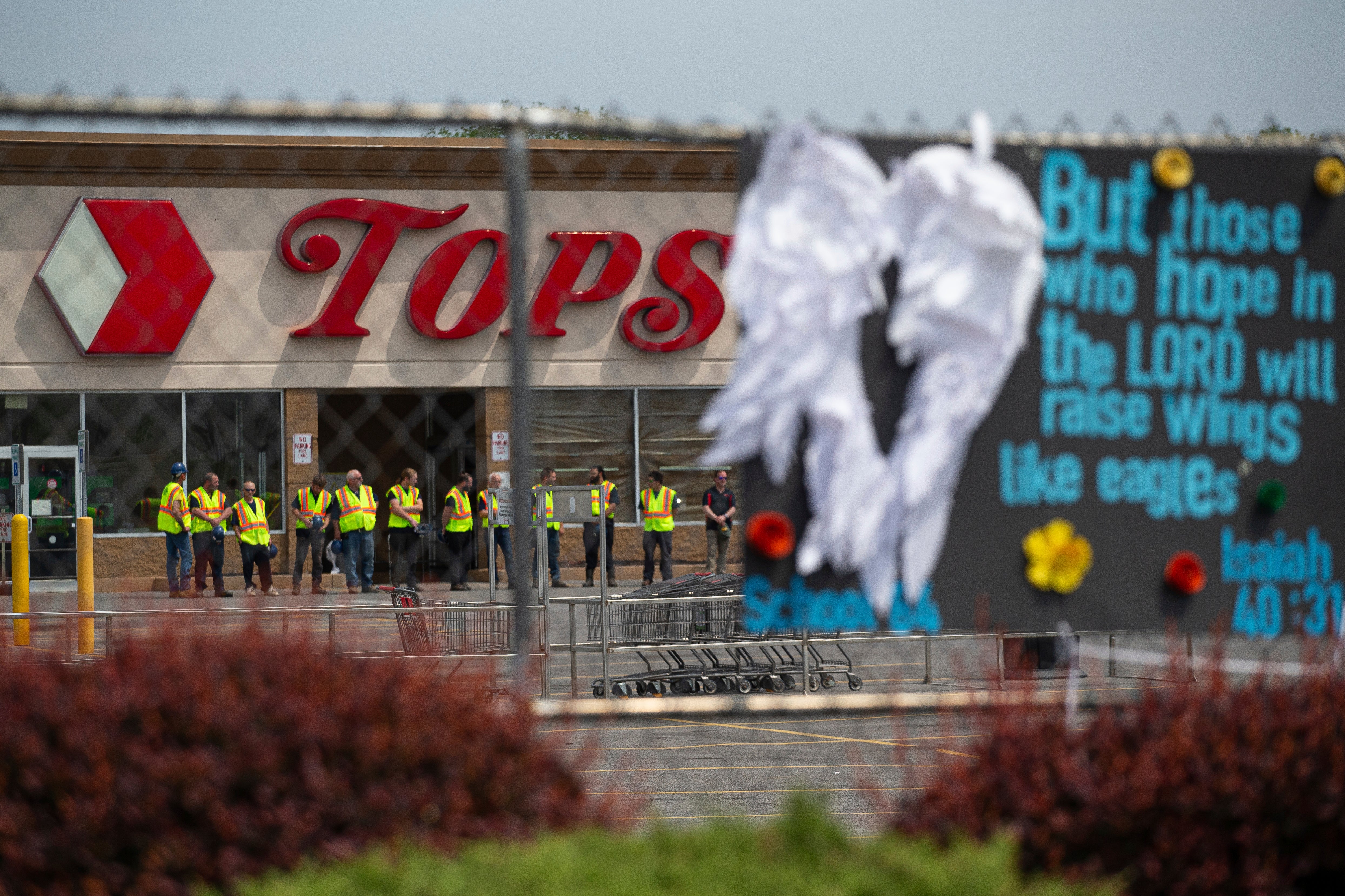 Investigators share a moment of silence for the victims of the Buffalo supermarket shooting outside the store one week on from the attack