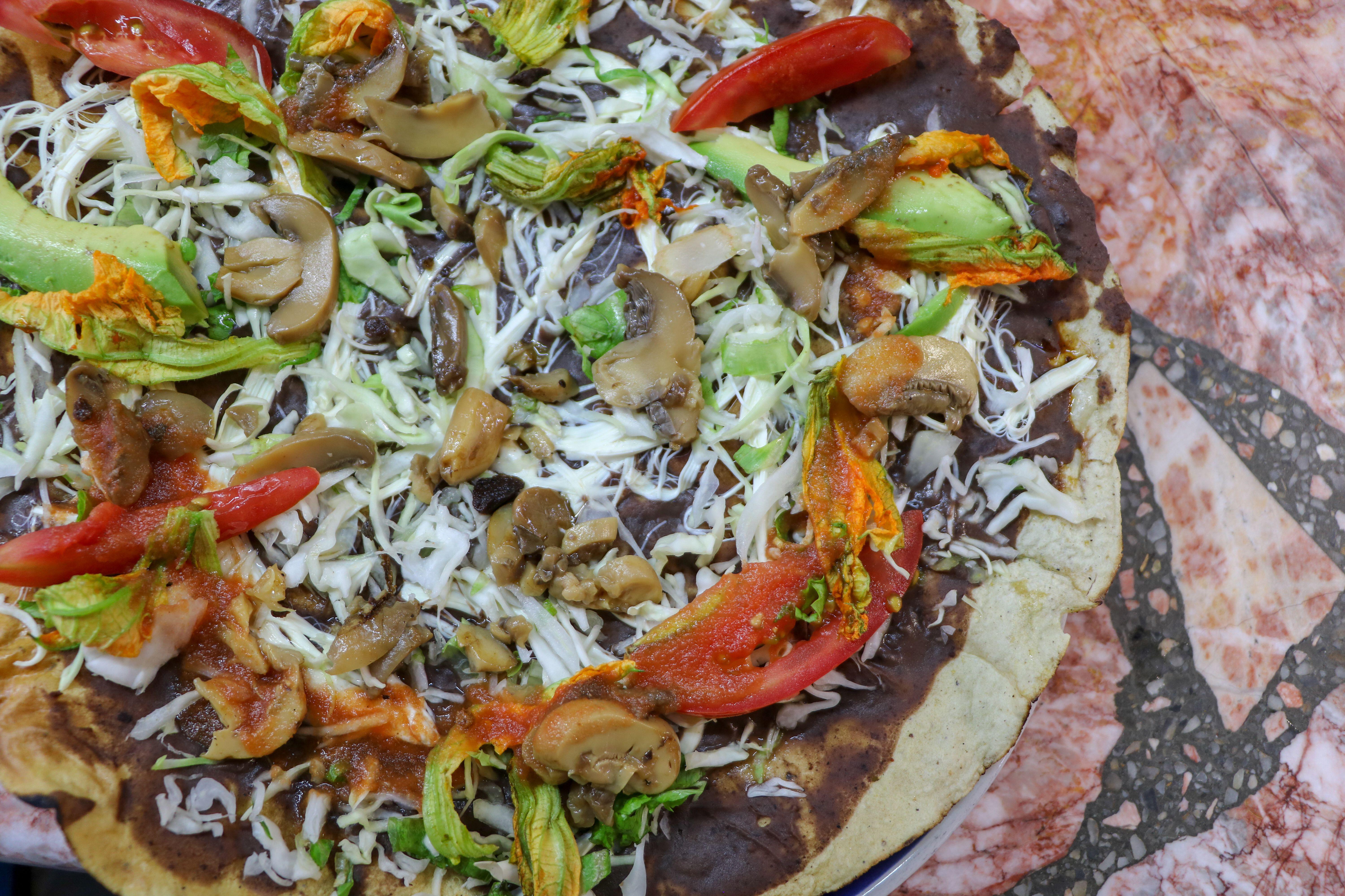 Tlayuda is a traditional Oaxacan dish cooked over a grill (Alamy/PA)