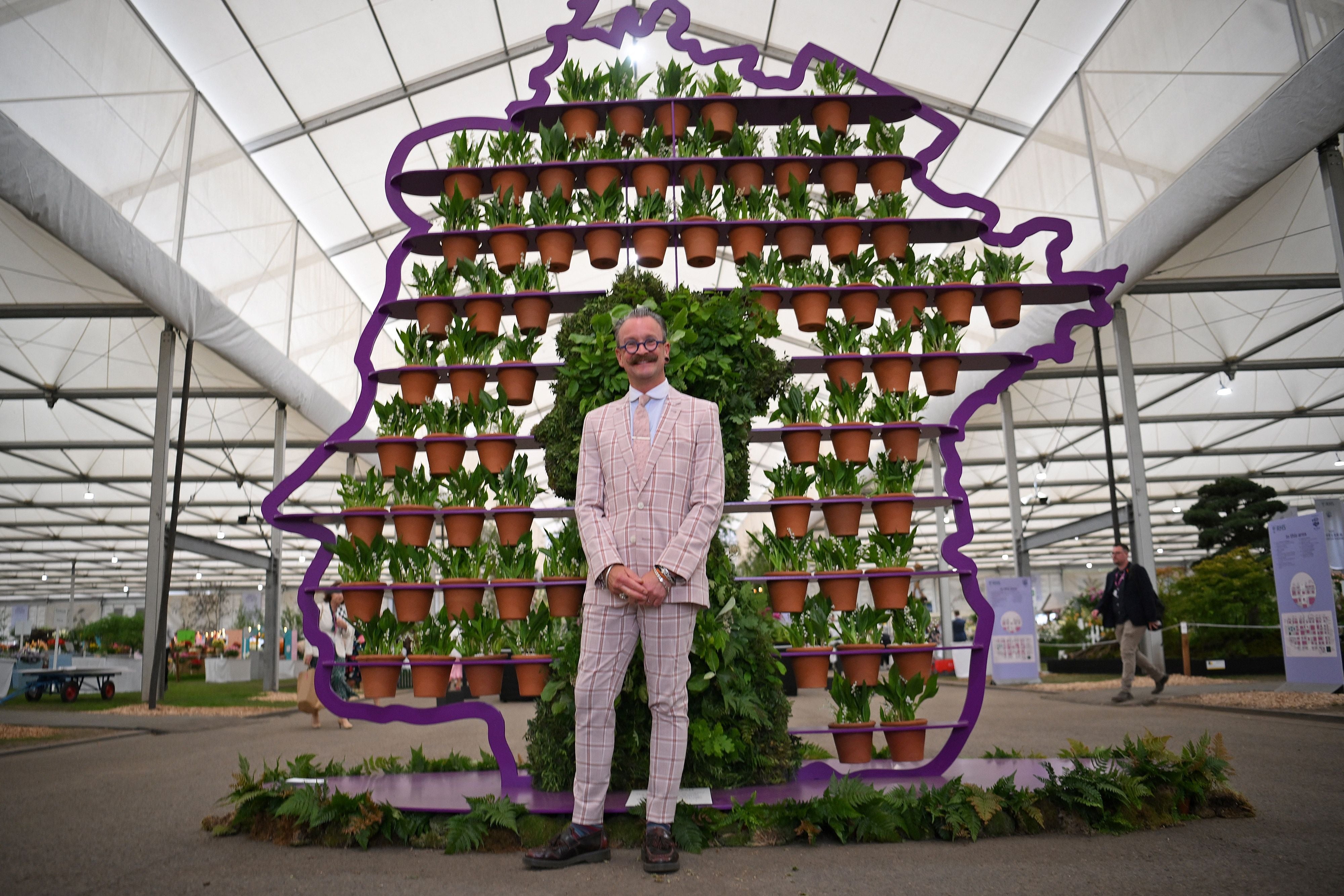 Florist Simon Lycett poses with a display of the Queen’s head he created using 70 flower pots – one for every year of her reign