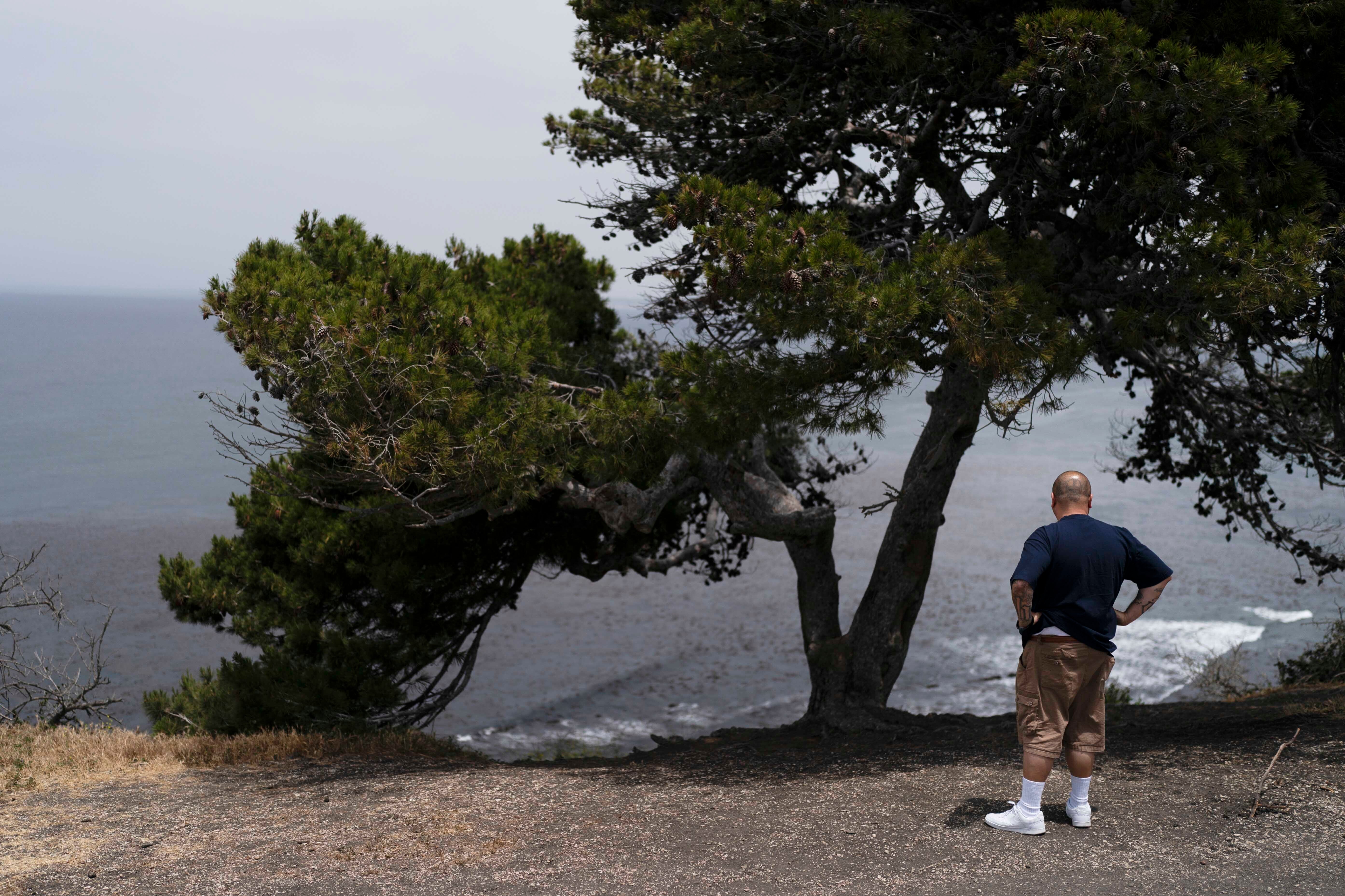 An onlooker stands near an ocean cliff in Palos Verdes Estates