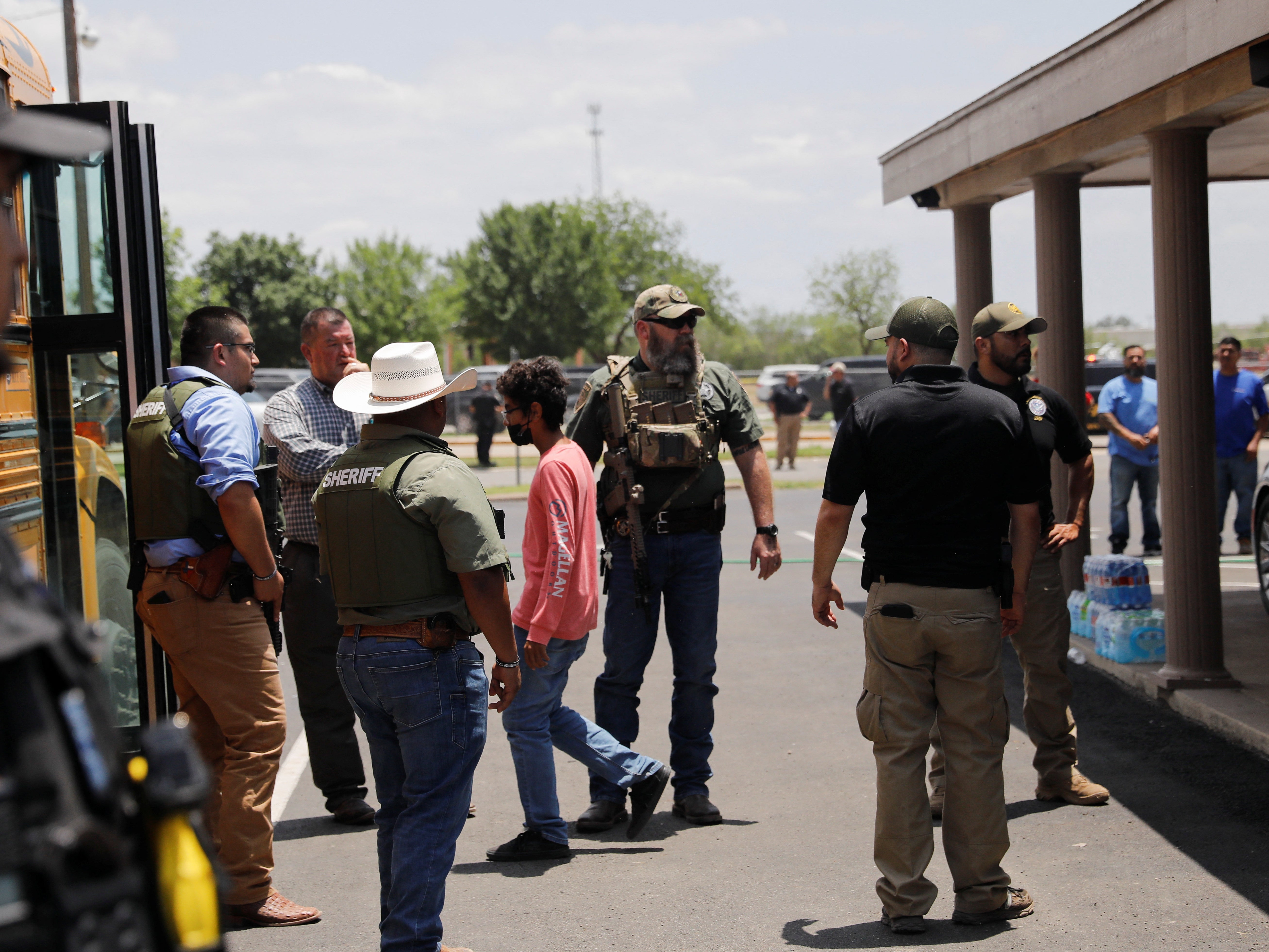 Children get on a school bus as law enforcement personnel guard the scene of a suspected shooting near Robb Elementary School in Uvalde, Texas, U.S. May 24, 2022