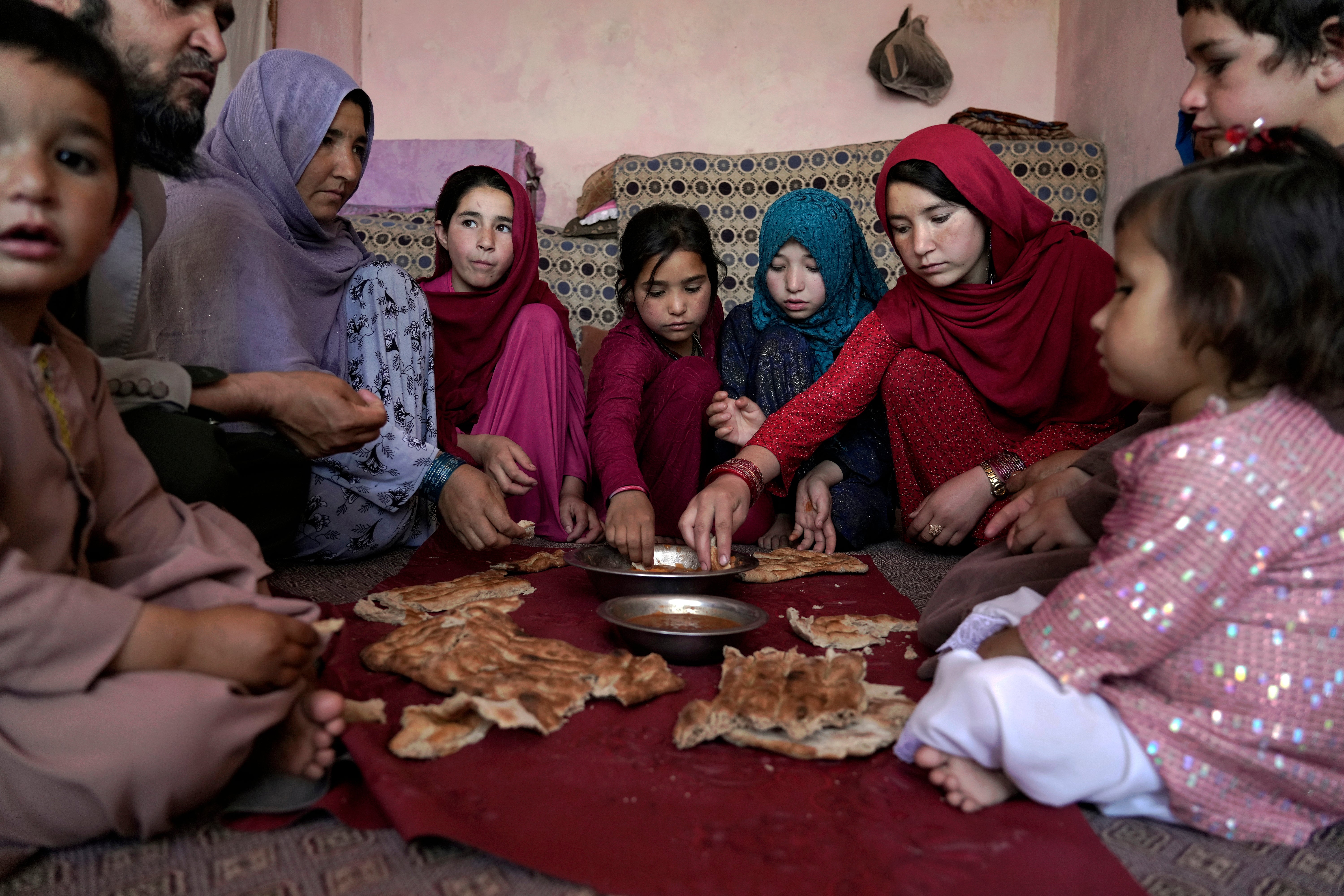 An Afghan family eat lunch in their home in one of Kabul's poor neighbourhoods in Kabul, Afghanistan