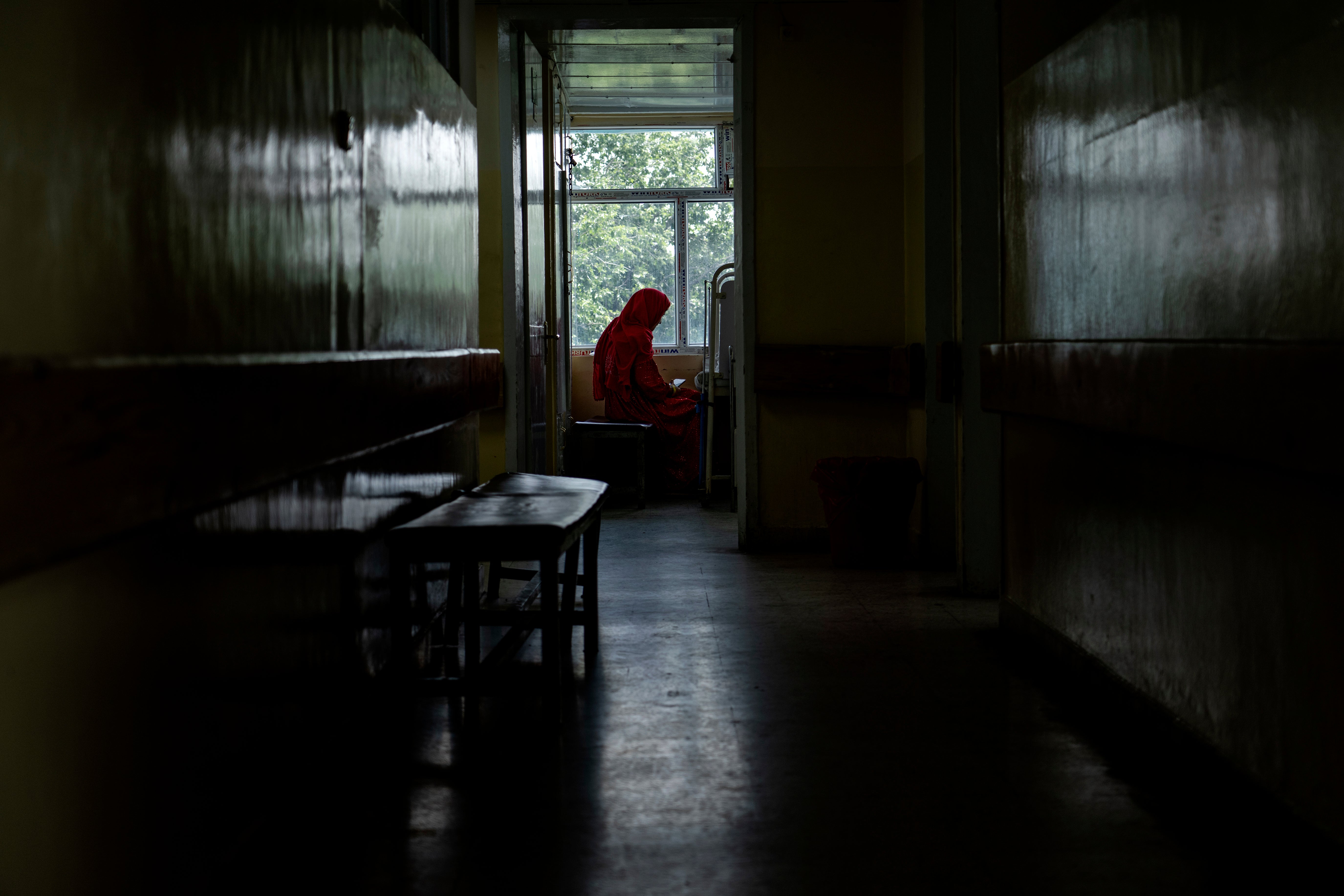 An Afghan mother sits by her child's bed at the malnutrition ward of the Indira Gandhi hospital in Kabul, Afghanistan