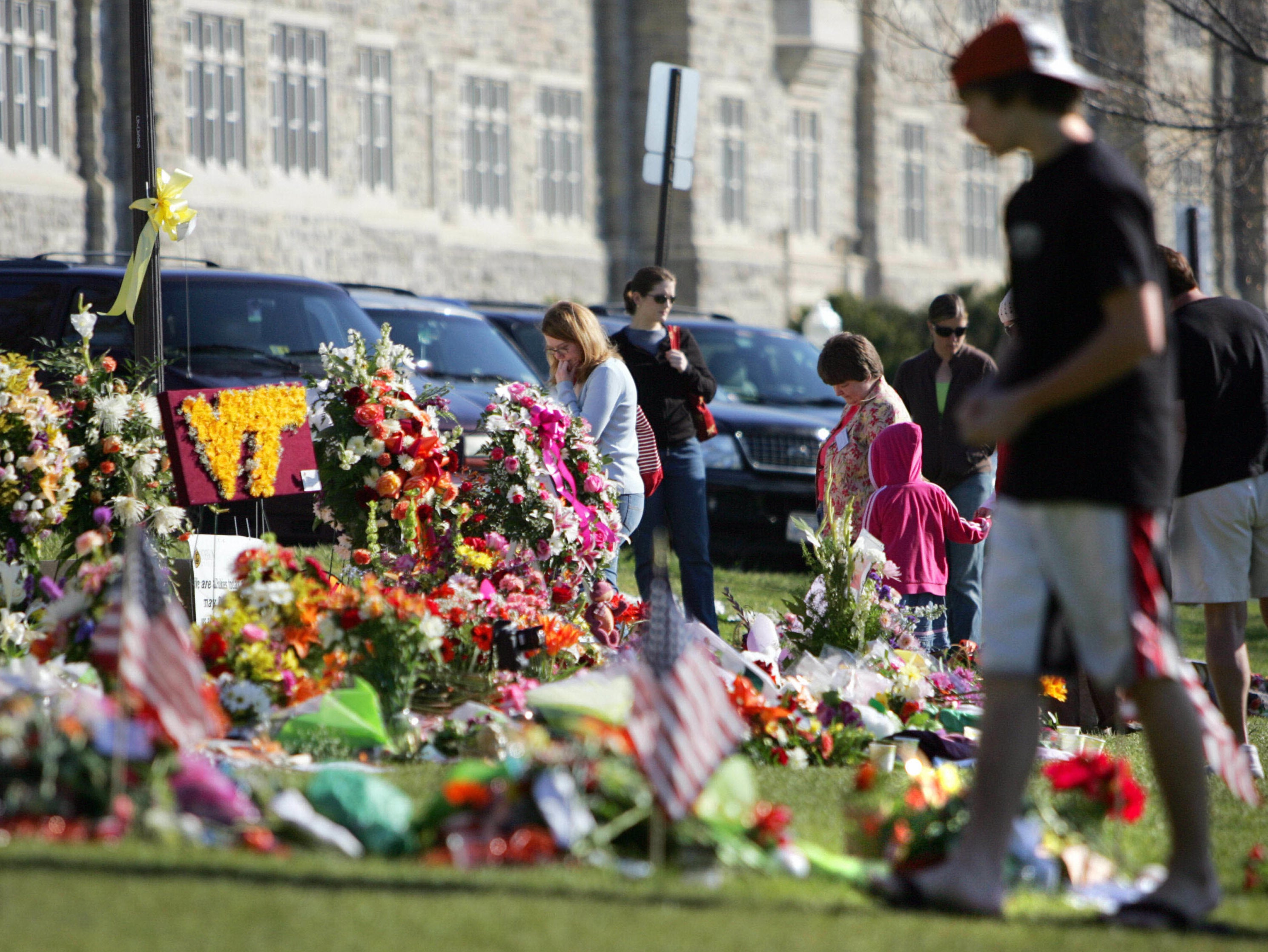 Mourners visit the “Hokie” stone memorial in honor of the 32 shooting victims at Virginia Tech in 2007