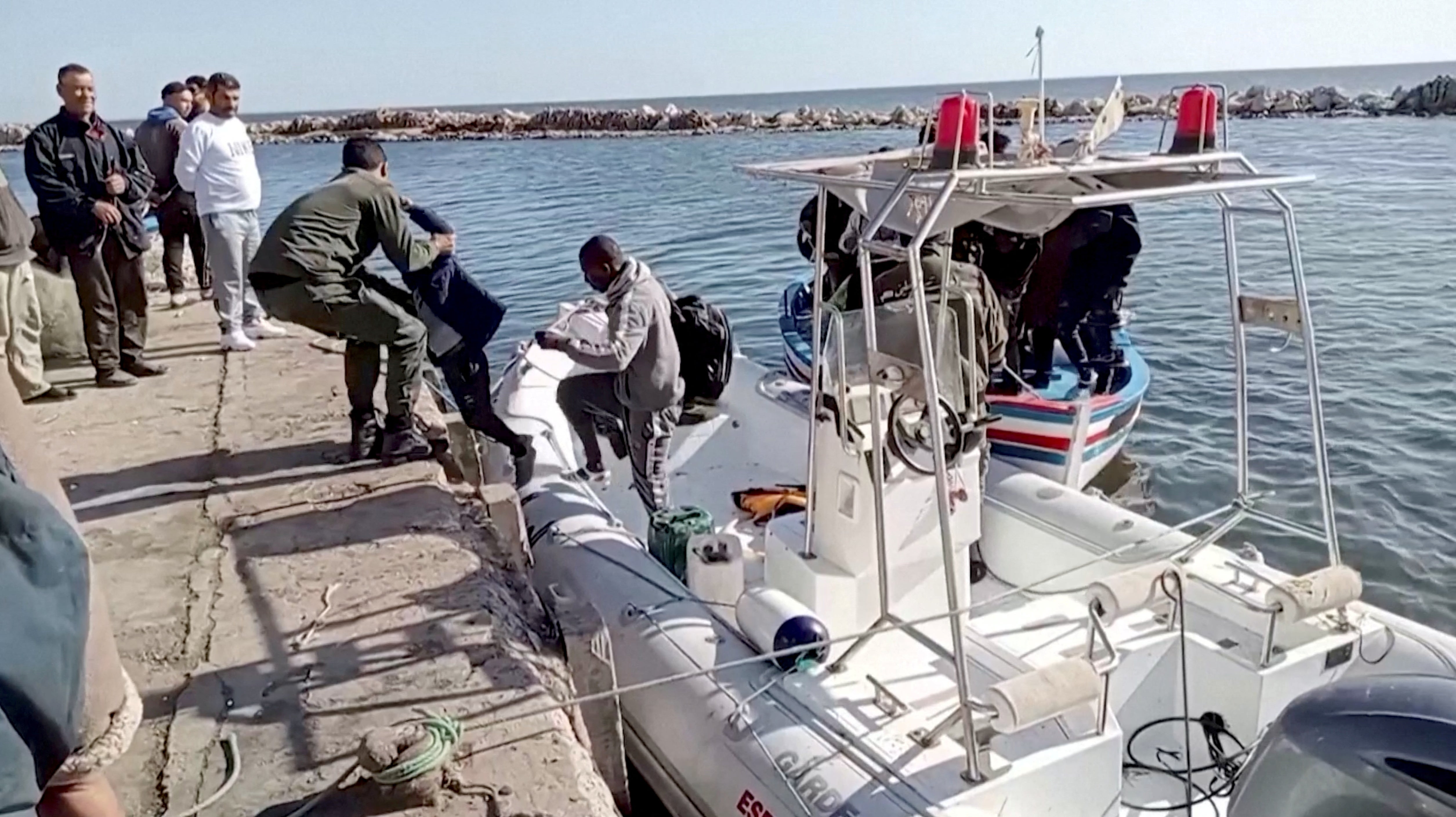 File photo: The Tunisian national coastguard helps a child to get off a rescue boat in Sfax