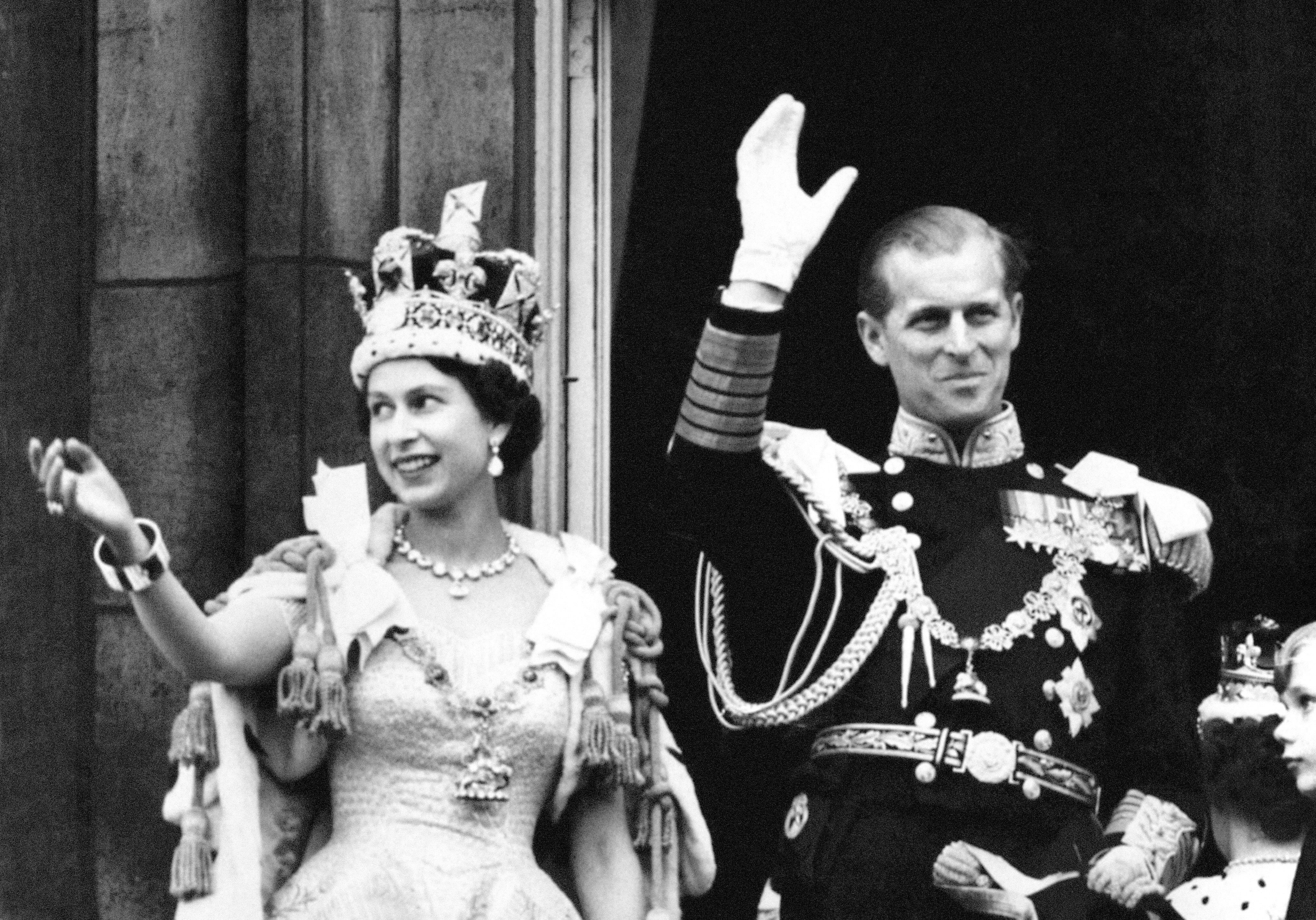 Queen Elizabeth II and the Duke of Edinburgh wave from the balcony at Buckingham Palace after the Coronation in 1953 (PA Archive)