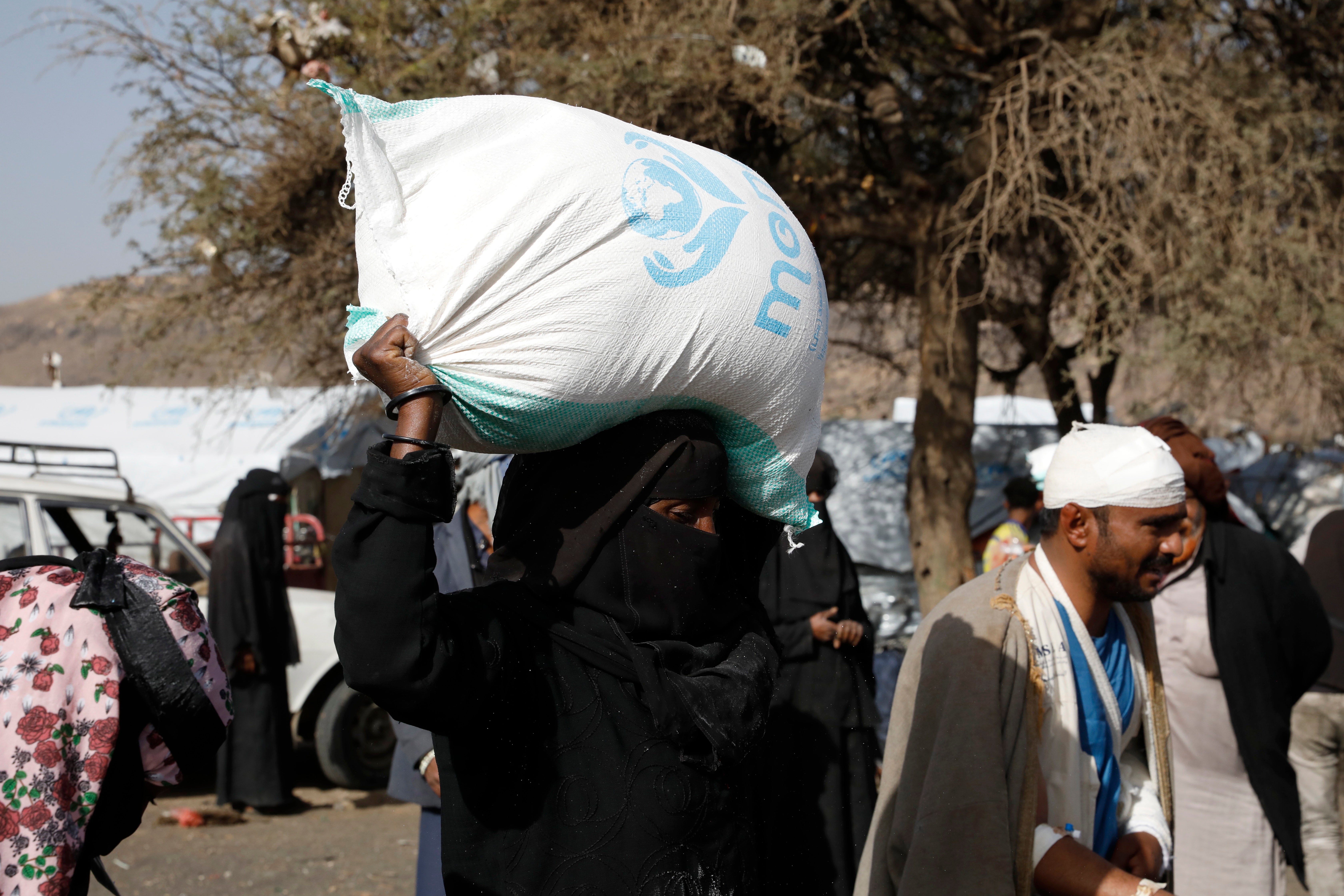 A displaced Yemeni woman gets emergency food aid on the outskirts of Sana’a