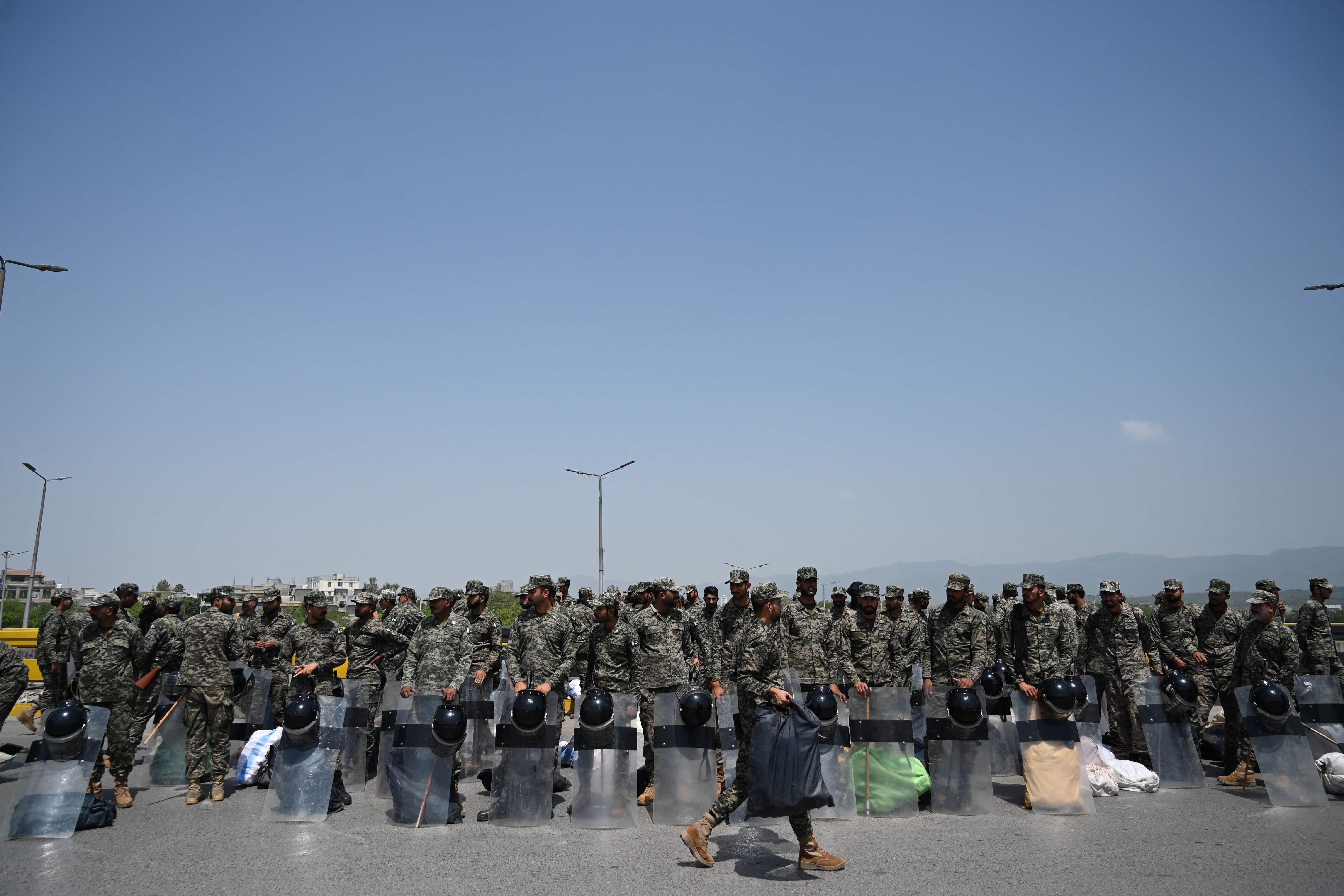 Rangers paramilitary personnel assemble near a blocked bridge along a road in Islamabad on Wednesday