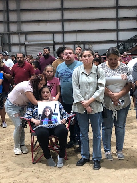 Loved ones of Naveah Bravo, who was killed on Tuesday, hold her picture as they gather with leaders and members of the community to commemorate the victims