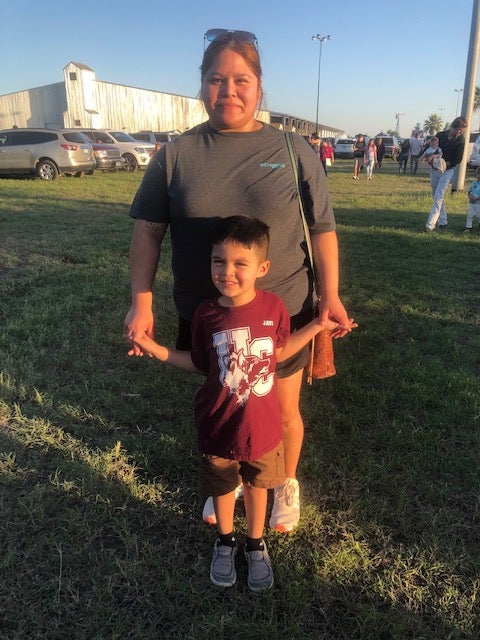 Brianna Gonzales picked her fourth-grader up early from Robb Elementary on Tuesday, not long before the shooting started; she stands outside the Uvalde County Fairplex with her younger son, Emilio