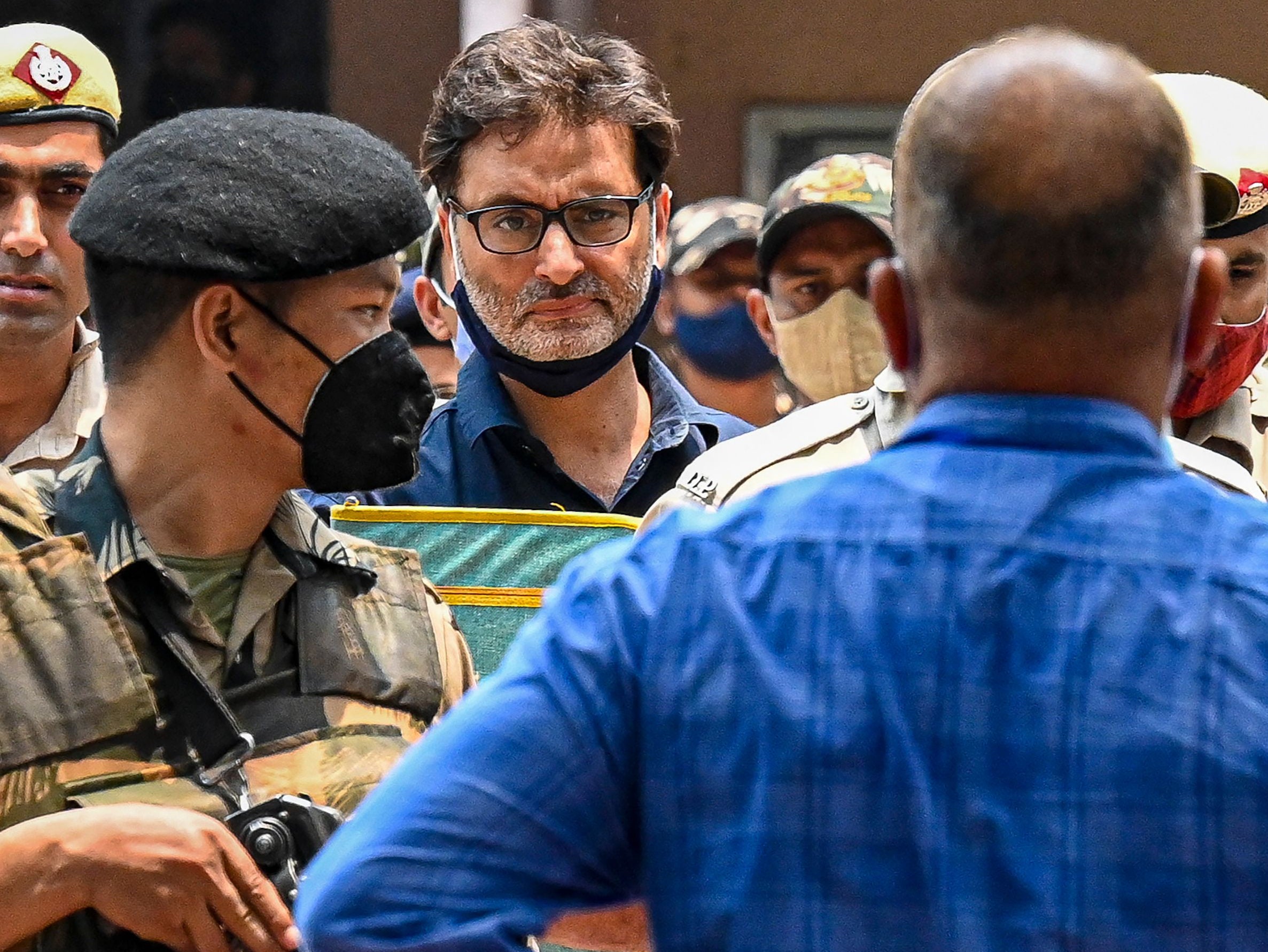 Police and security personnel escort Yasin Malik, chairman of the Jammu Kashmir Liberation Front