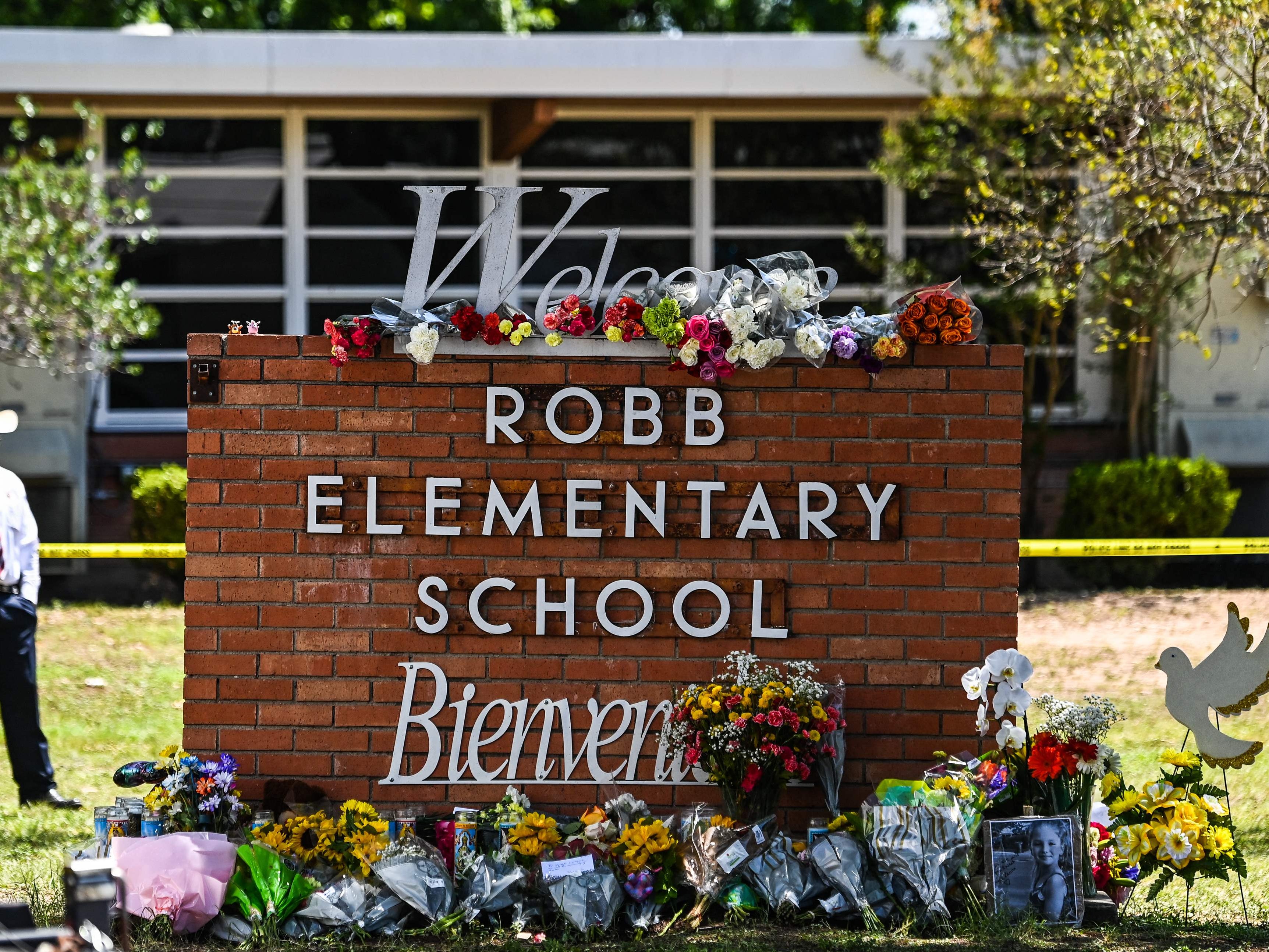 Flowers are placed on a makeshift memorial in front of Robb Elementary School