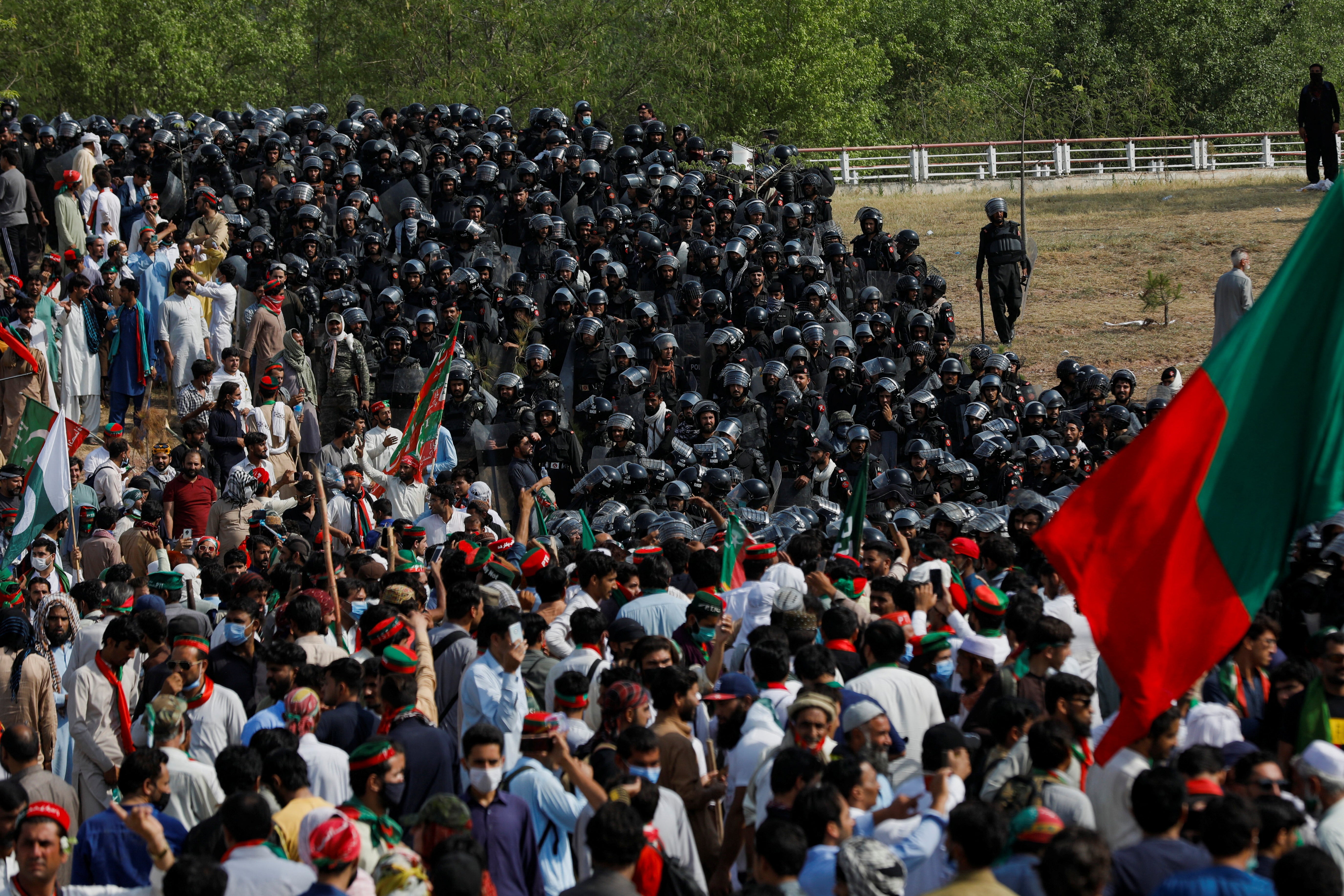 Police officers in riot gear stand guard to stop supporters of the Pakistan Tehreek-e-Insaf political party in Islamabad on 26 May