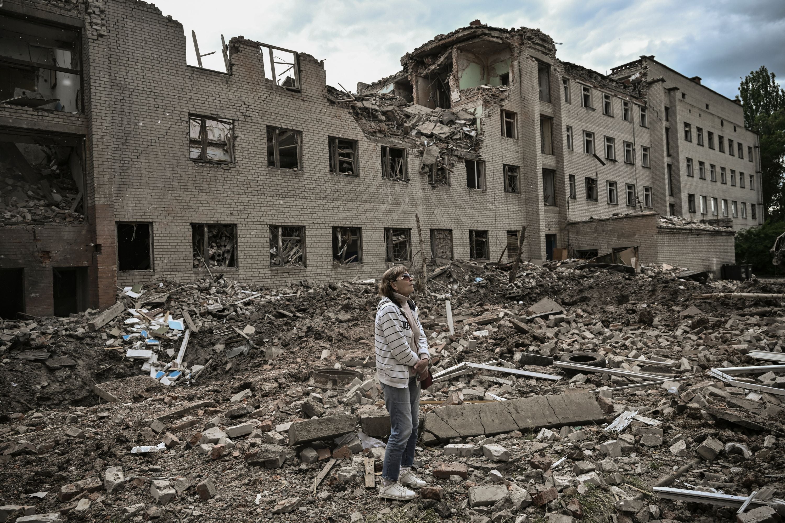 A woman stands in front of an administrative building shelled by the Russians in Bakhmut in the eastern Ukraine region of Donbas