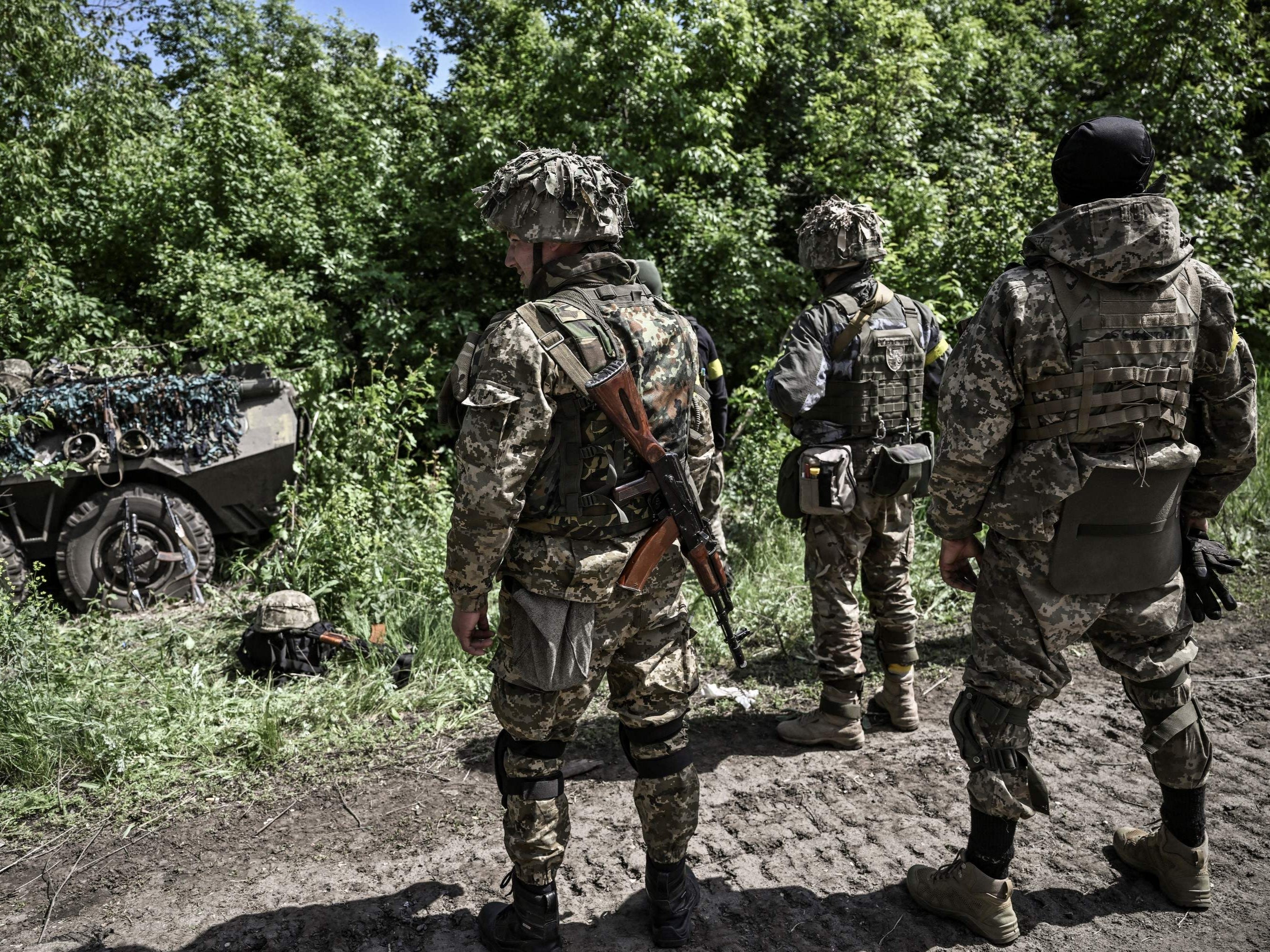 Ukrainian servicemen get ready to move towards the front line at a checkpoint near the city of Lysychansk