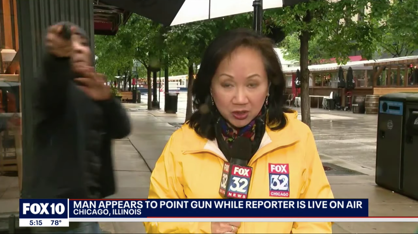 A man jumped behind a Fox News reporter while she was doing a report on the air and pointed what appeared to be a gun at the cameraman and then walked away.