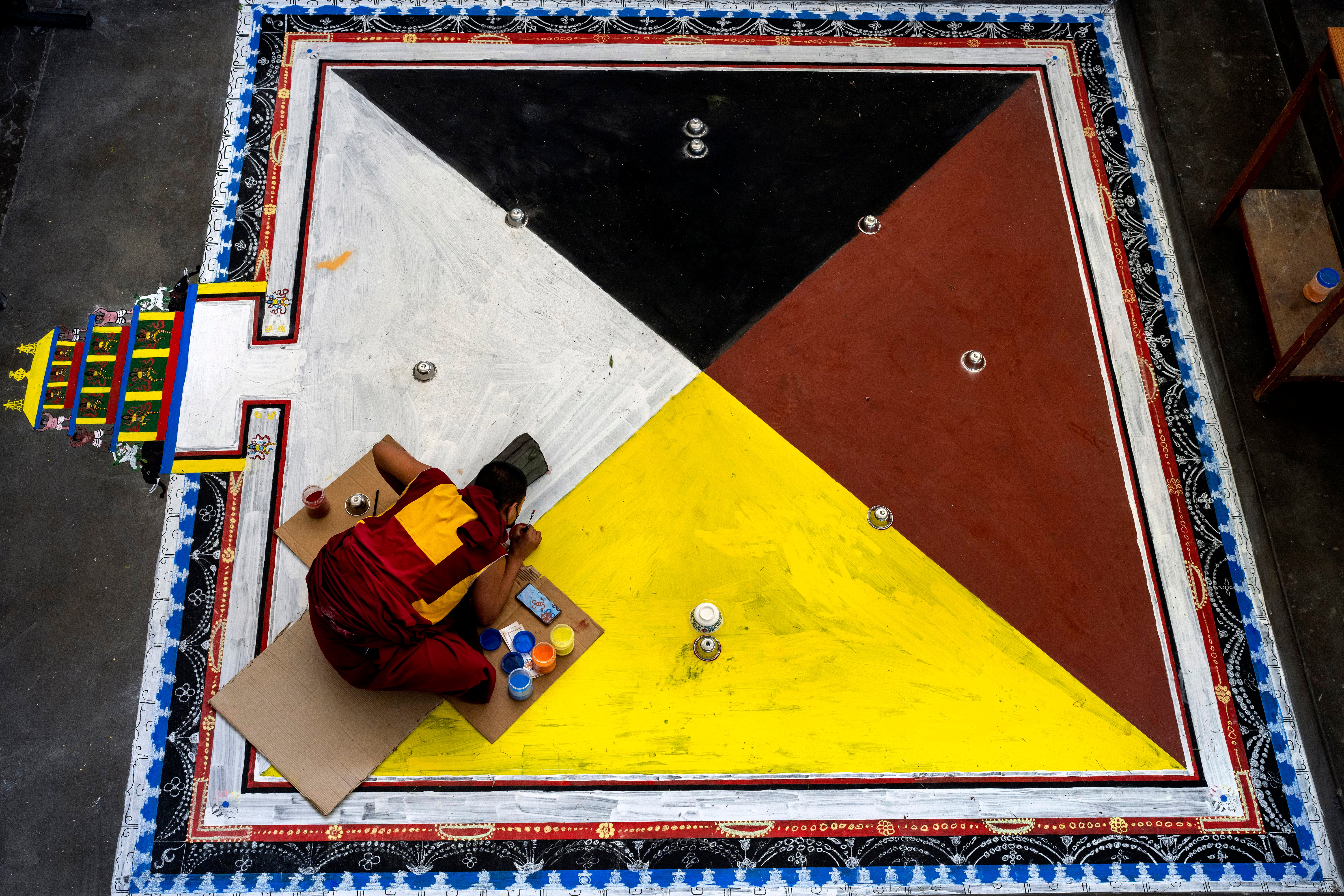 File photo: An exile Tibetan Buddhist monk creates a traditional motif on the floor in preparation for ritual prayers in Dharmsala, India on 20 May