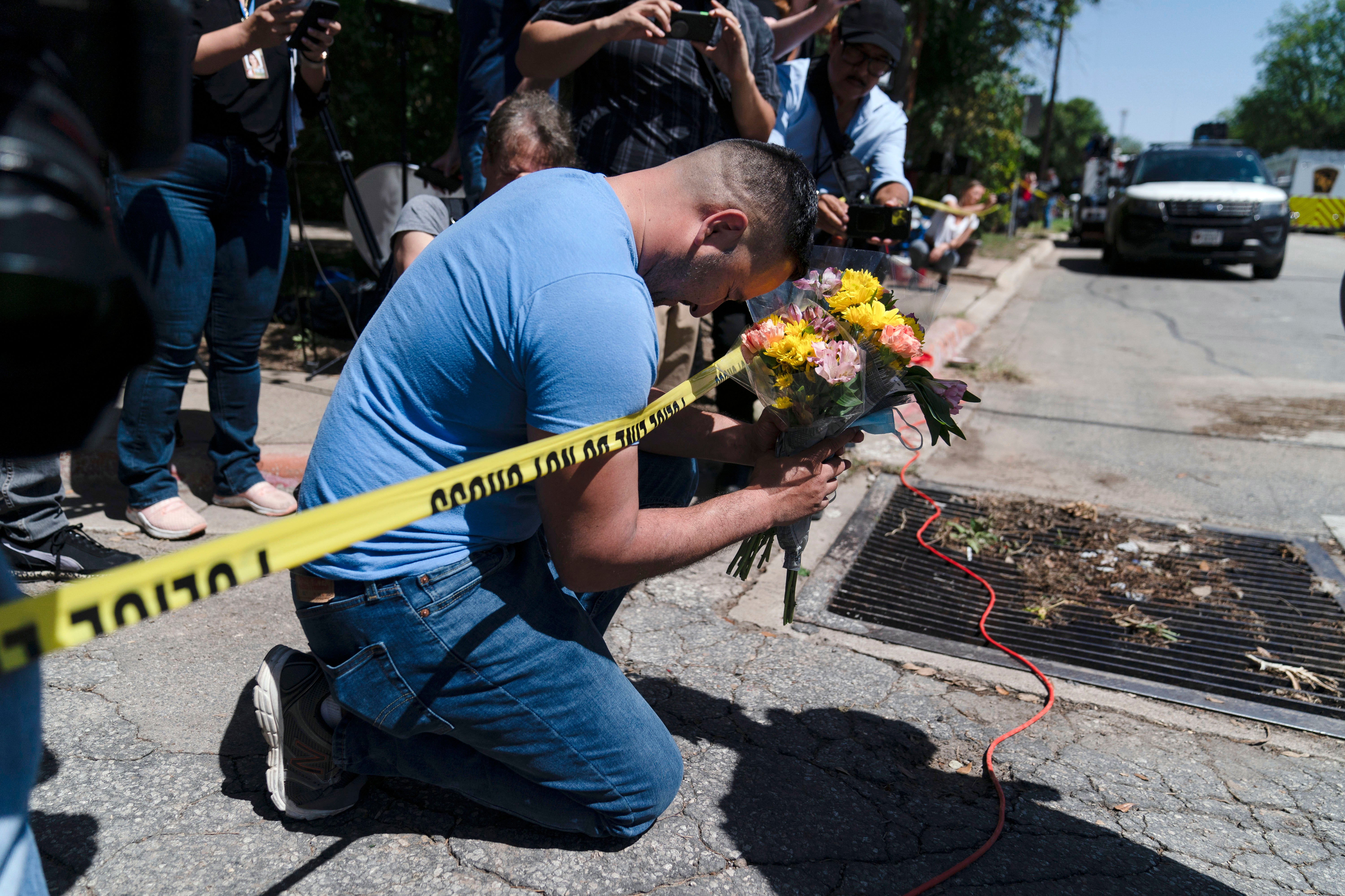 Joseph Avila prays while holding flowers honouring the victims of Tuesday's mass shooting at Robb Elementary School in Uvalde, Texas