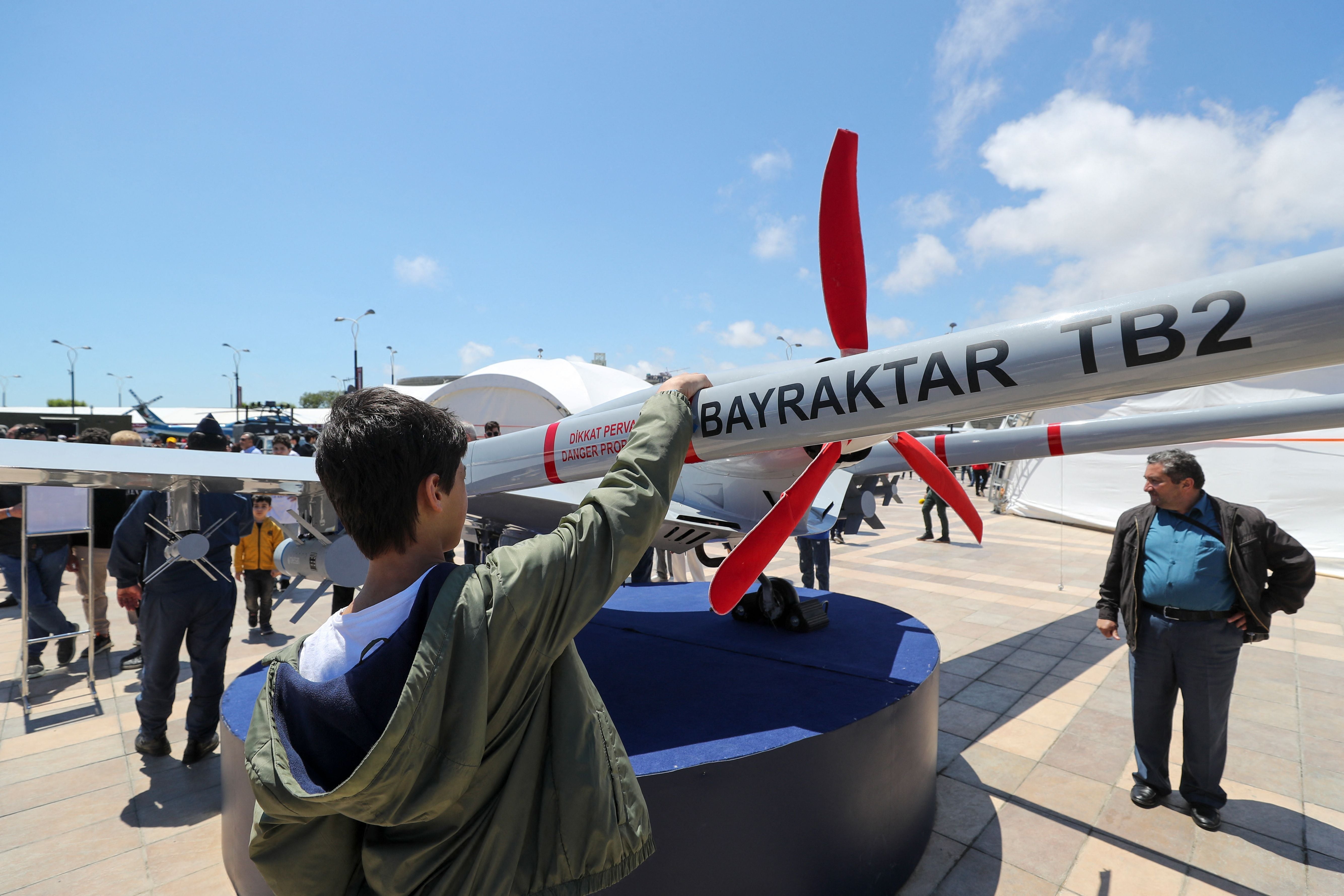 A young man looks at the Bayraktar TB2 drone, manufactured by Turkey’s Baykar