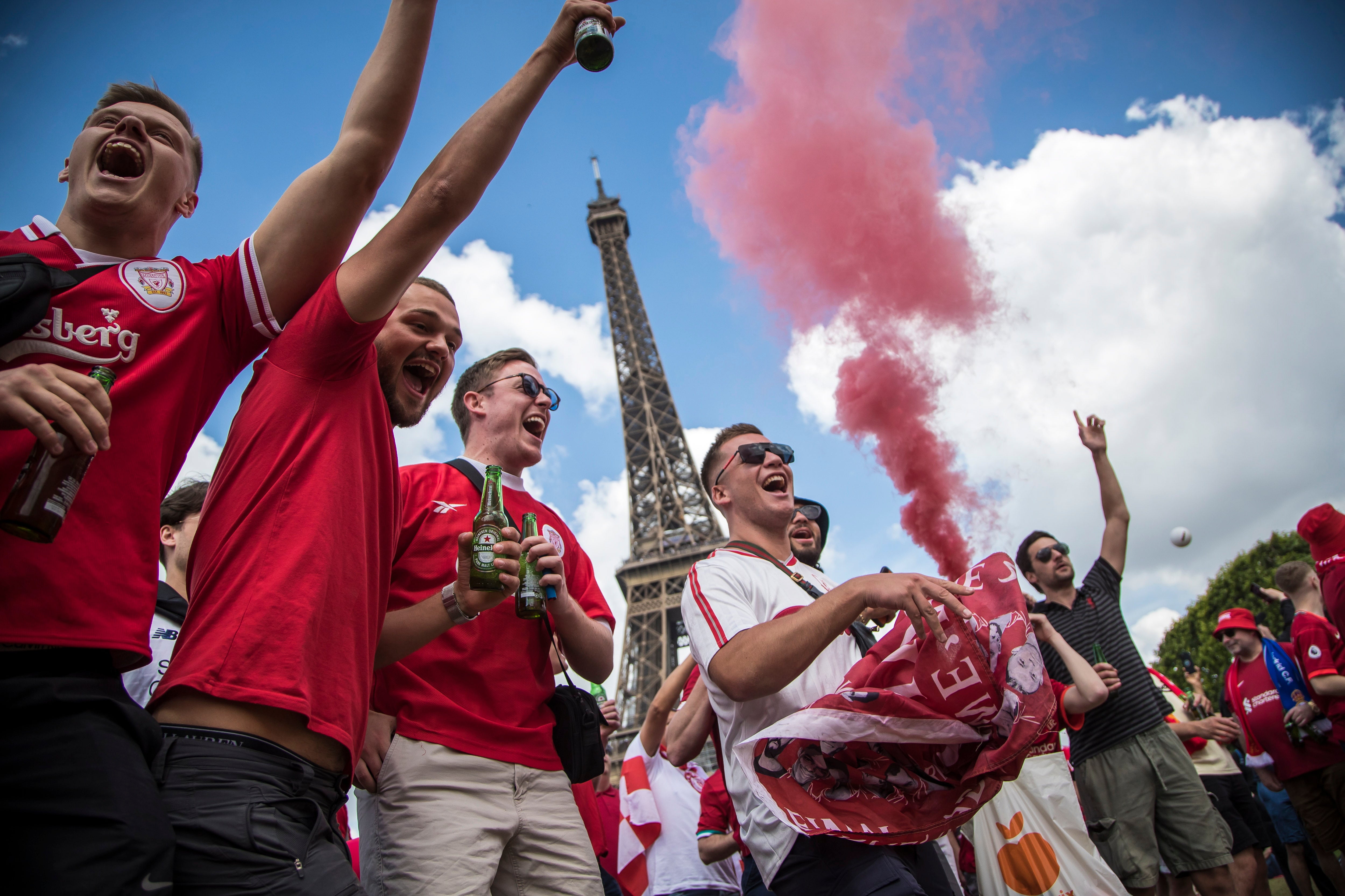 Fans cheer for their team as they gather near the Eiffel Tower