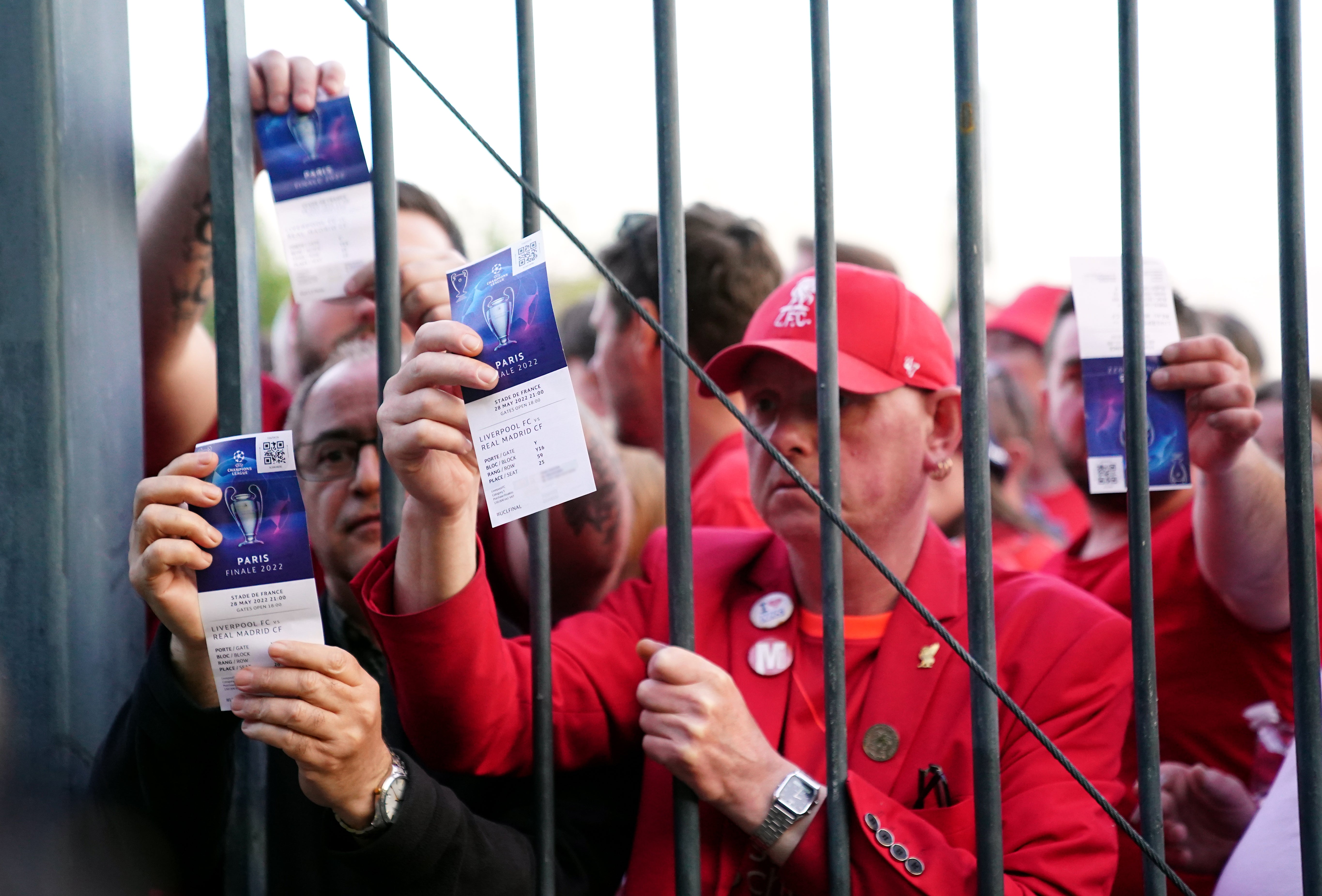 Liverpool fans stuck outside the ground show their match tickets