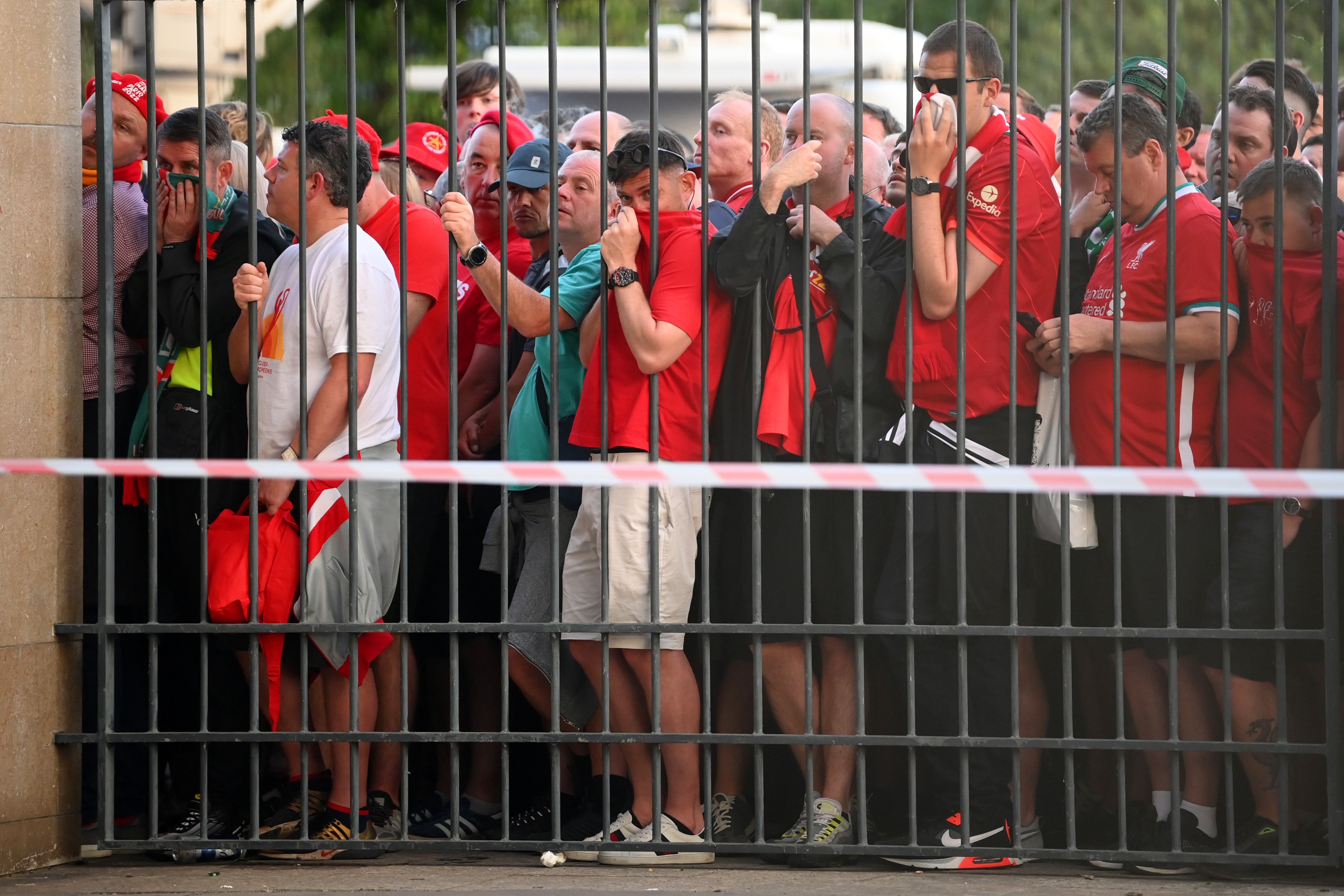 Liverpool fans cover their faces after police deployed tear gas