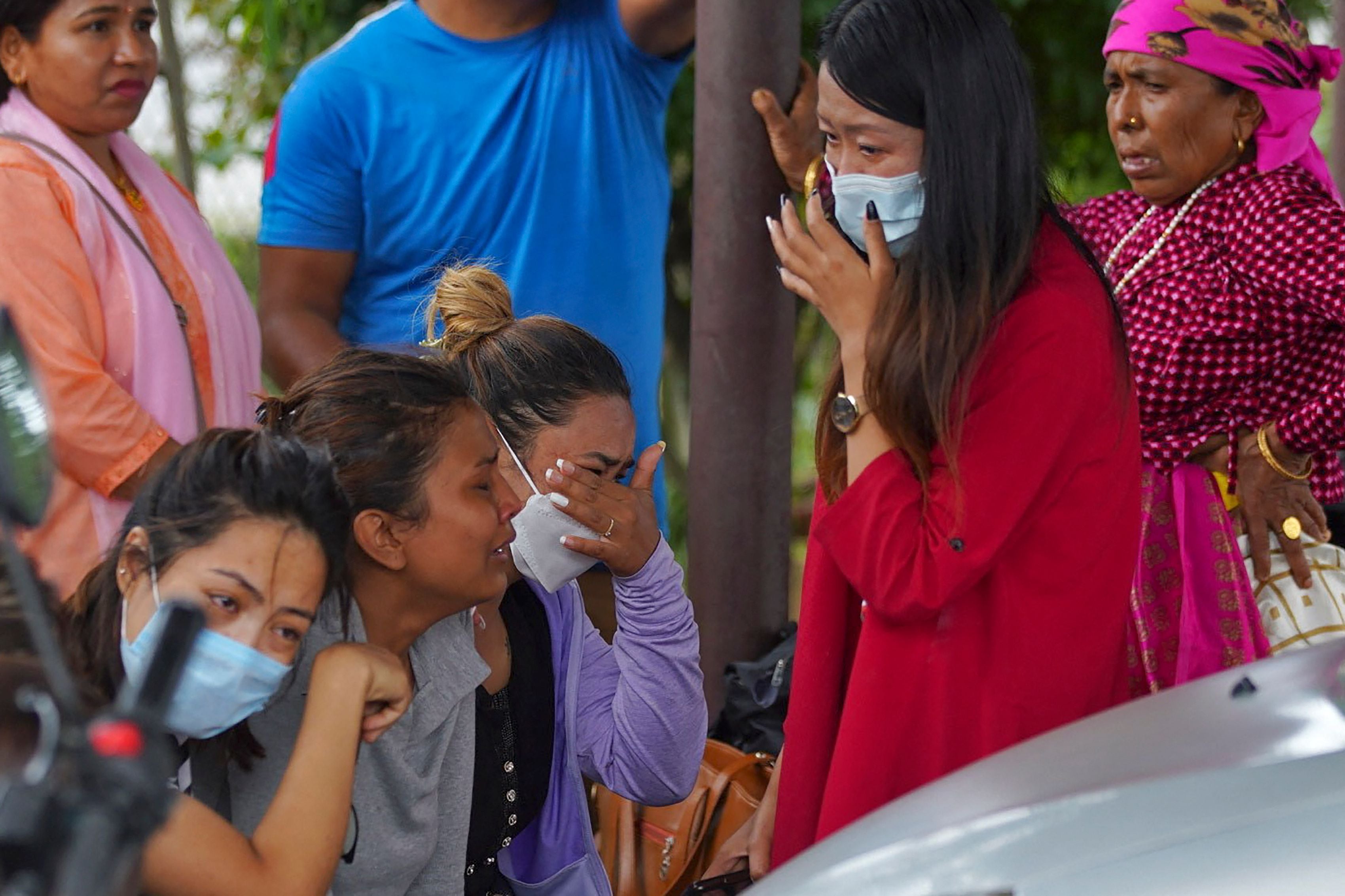 Family members and relatives of passengers on board the Twin Otter aircraft operated by Tara Air weep outside the airport in Pokhara on 29 May