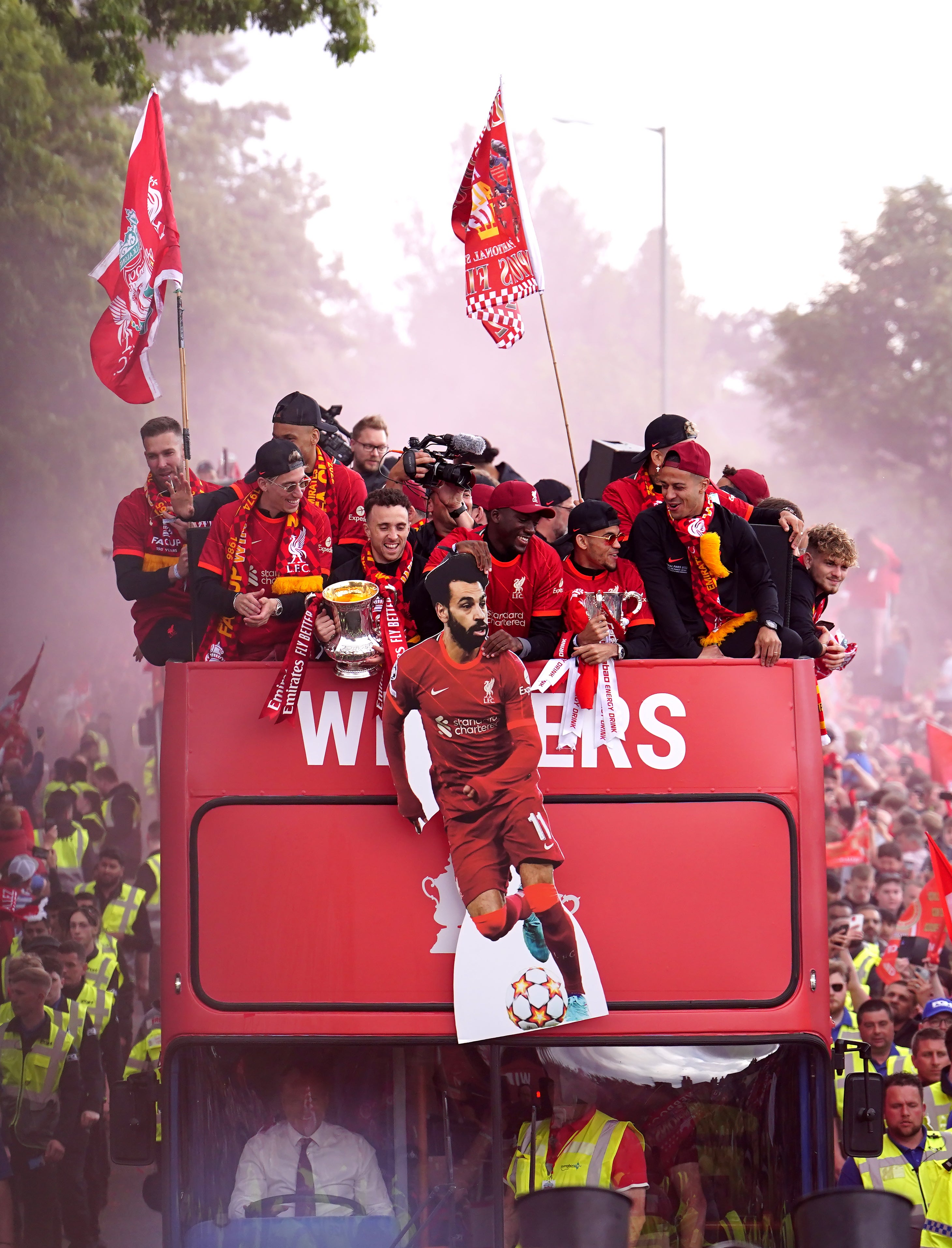 Liverpool players wave a cardboard cut-out of Mohamed Salah in front of the top deck of the bus (Martin Rickett/PA)