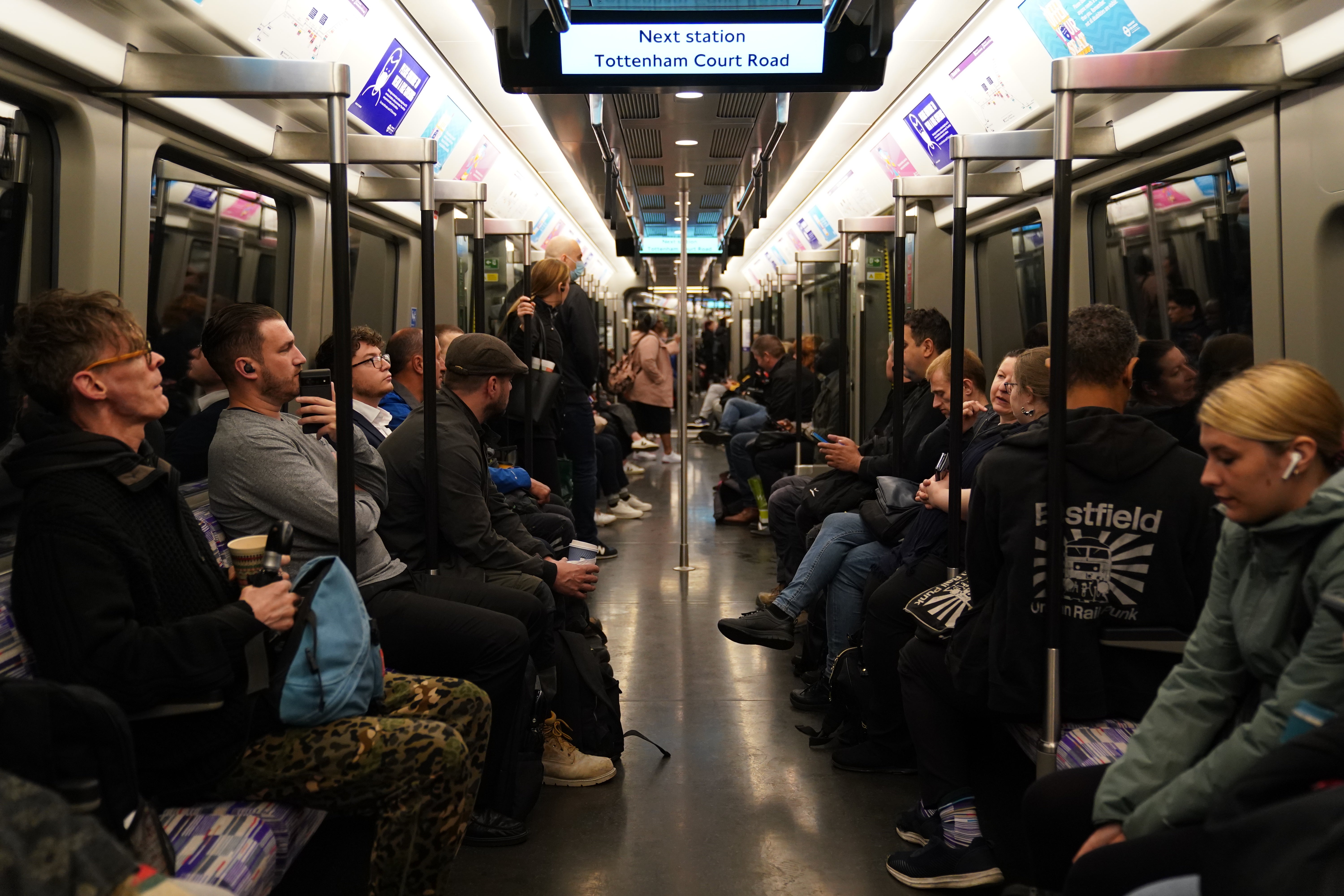 Passengers on board an Elizabeth Line train approaching Tottenham Court Road station in London, as the new line opens to passengers for the first time. The delayed and overbudget line will boost capacity and cut journey times for east-west travel across the capital (Kirsty O’Connor/PA)