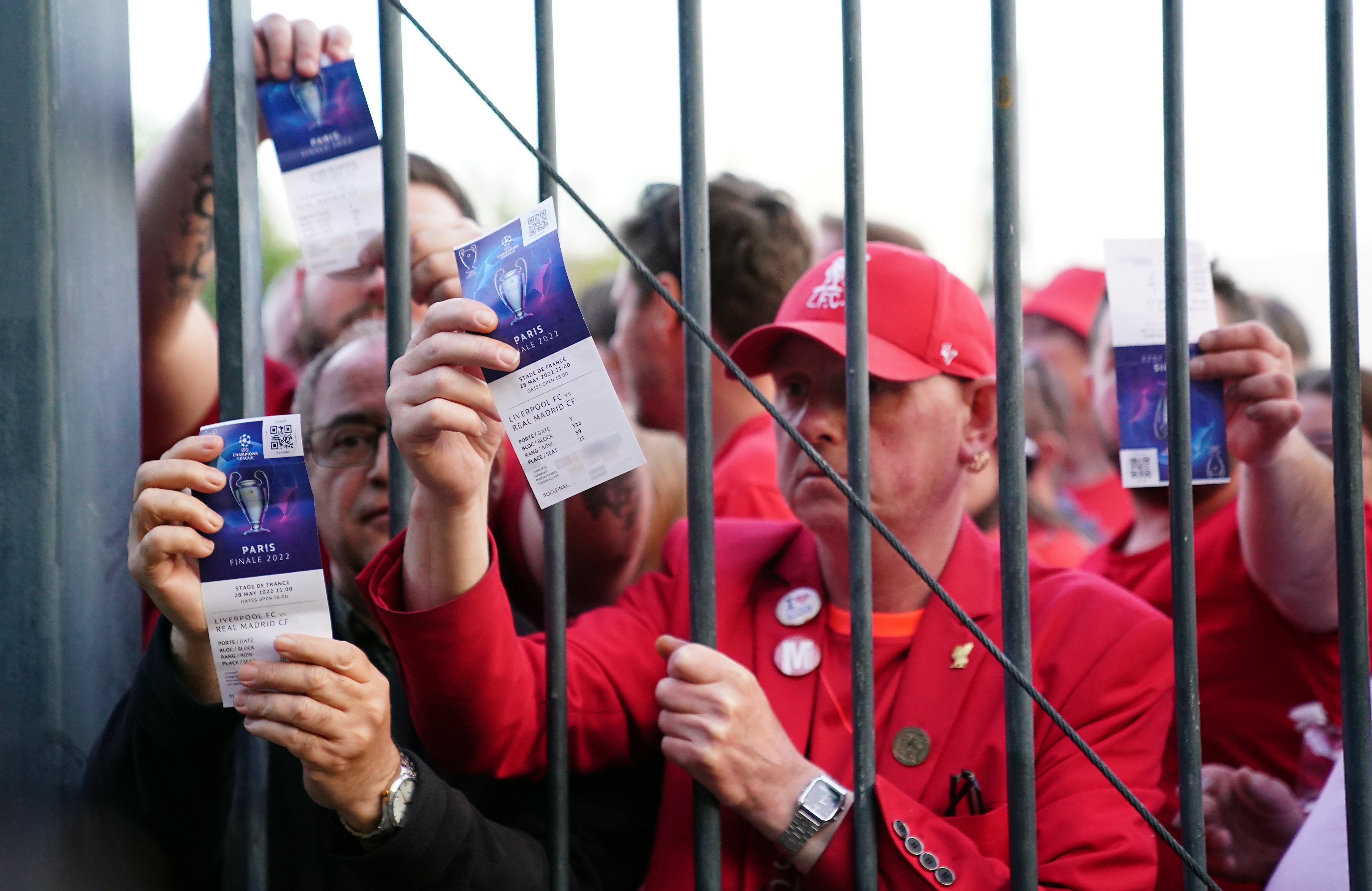 Liverpool fans stuck outside the ground on Saturday show their match tickets