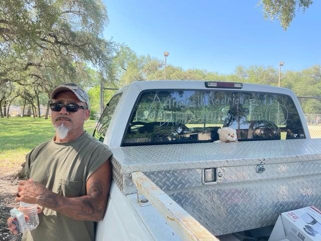 Jessie Rodriguez stands in Uvalde near his pickup, on which he has written ‘Annabell Rodriguez Daddy Missing You’ with a hand-drawn broken heart