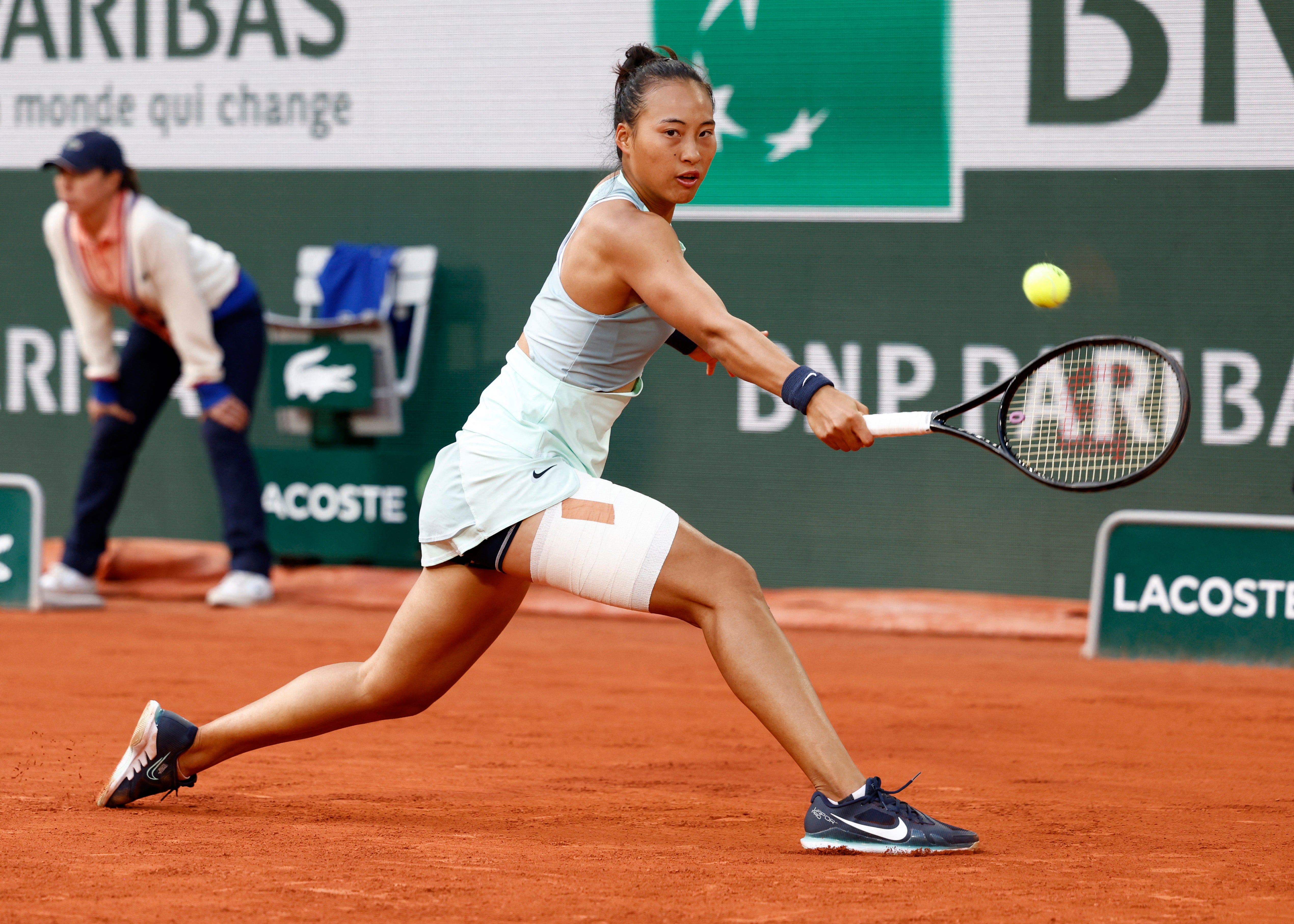 Qinwen Zheng with leg strappings during her fourth round match against Poland's Iga Swiatek