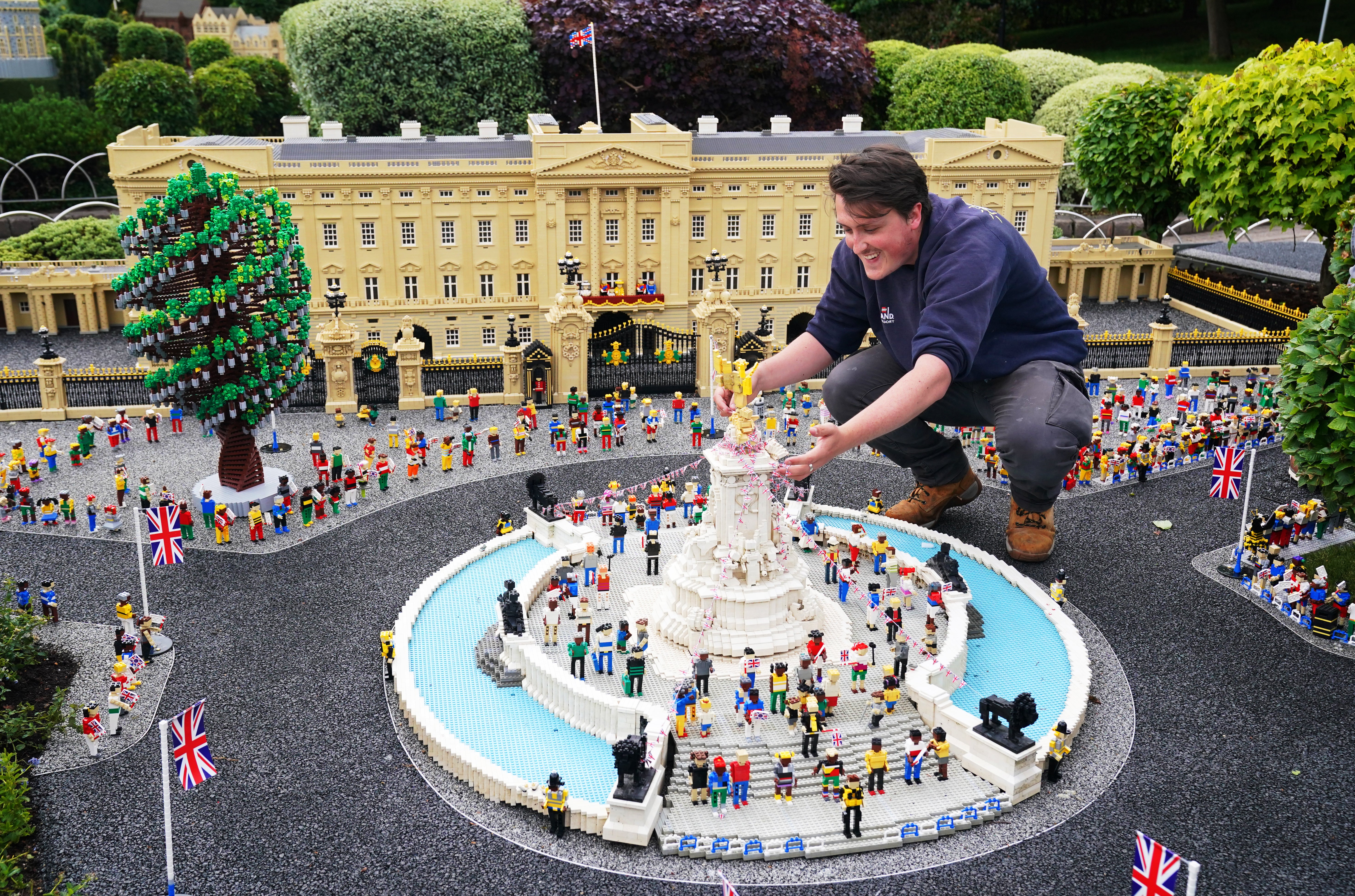 Legoland Windsor staff member attends to a Lego construction of Buckingham Palace