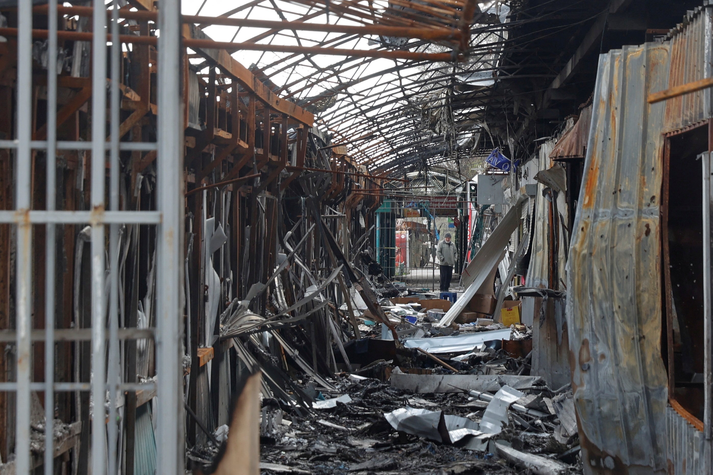 A local resident stands next to debris of an open market destroyed by a military strike, as Russia's attack on Ukraine continues, in Sievierodonetsk, Luhansk region