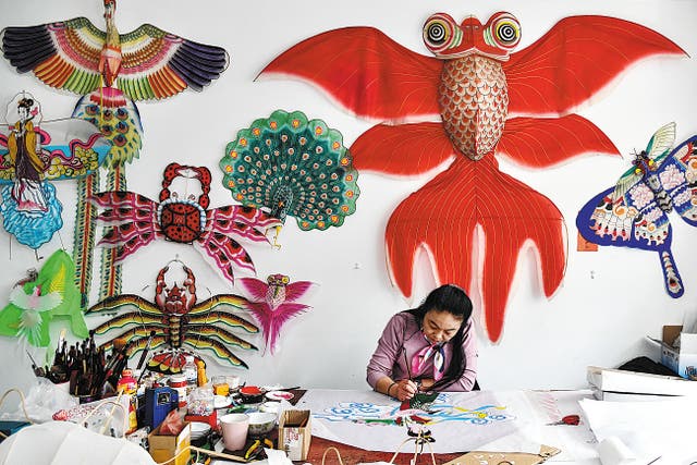 <p>Yang Hongwei, an intangible cultural heritage inheritor of Weifang kite-making in Yangjiabu village, Weifang, Shandong province, paints a kite in April 2021 </p>