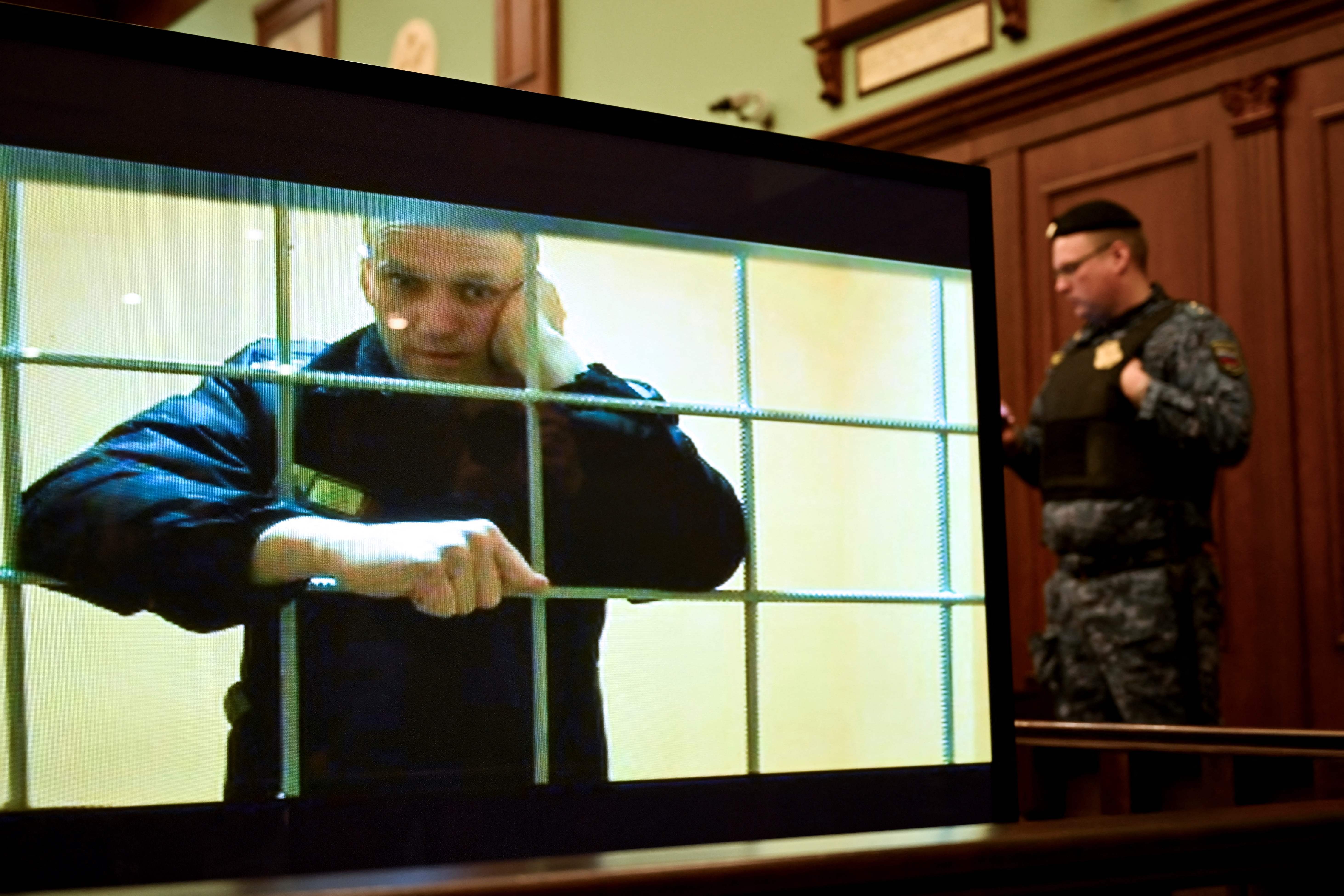 Alexei Navalny appears on a screen set up at a courtroom of the Moscow City Court