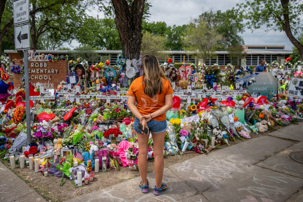 Community resident Cesia, 37, pays her respects at a memorial dedicated to the 19 children and two adults