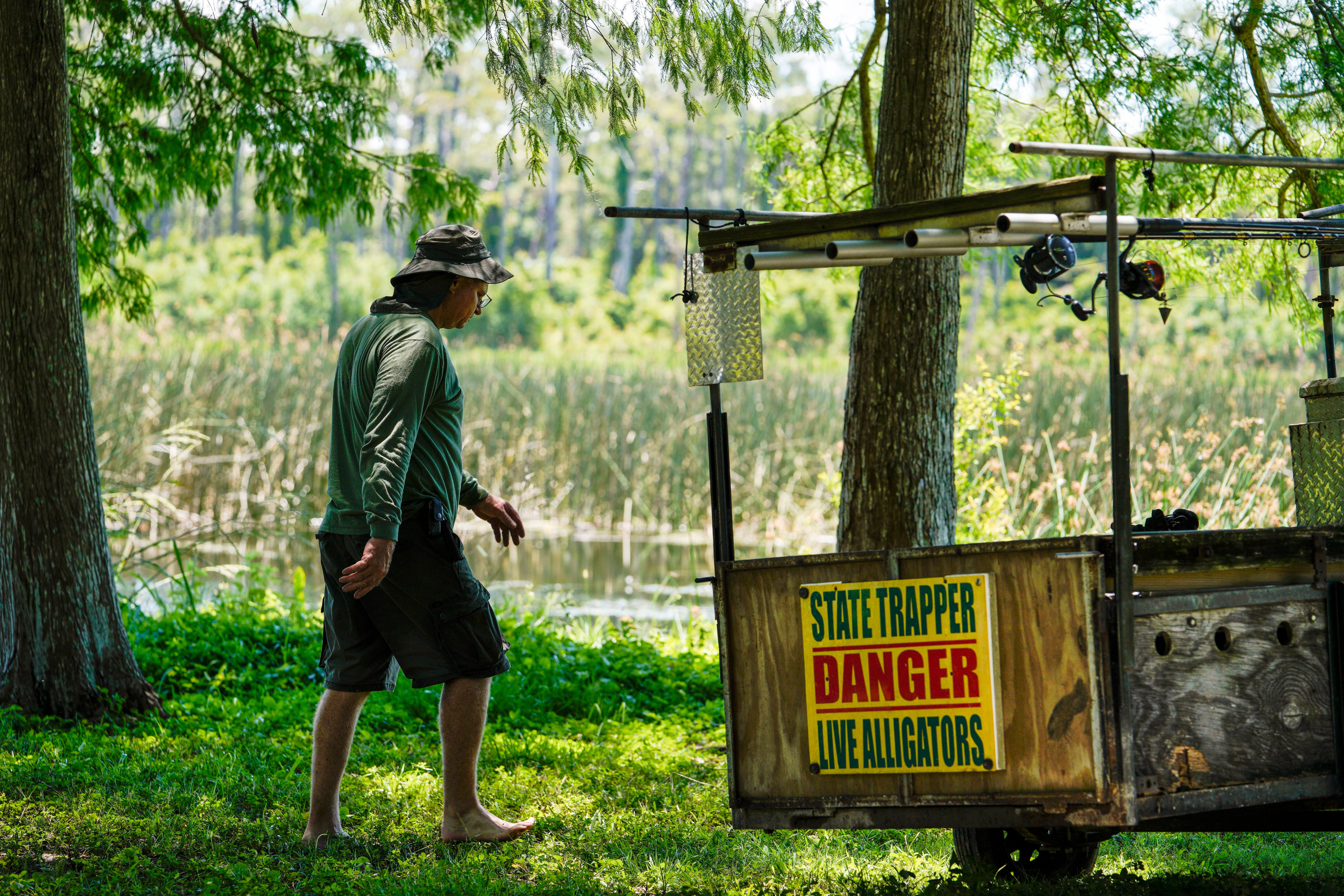 A state-contracted alligator trapper walks near the area where a man was found dead after going into the water to retrieve lost disc golf discs at John S. Taylor Park, Tuesday, May 31, 2022 in Largo, Fla