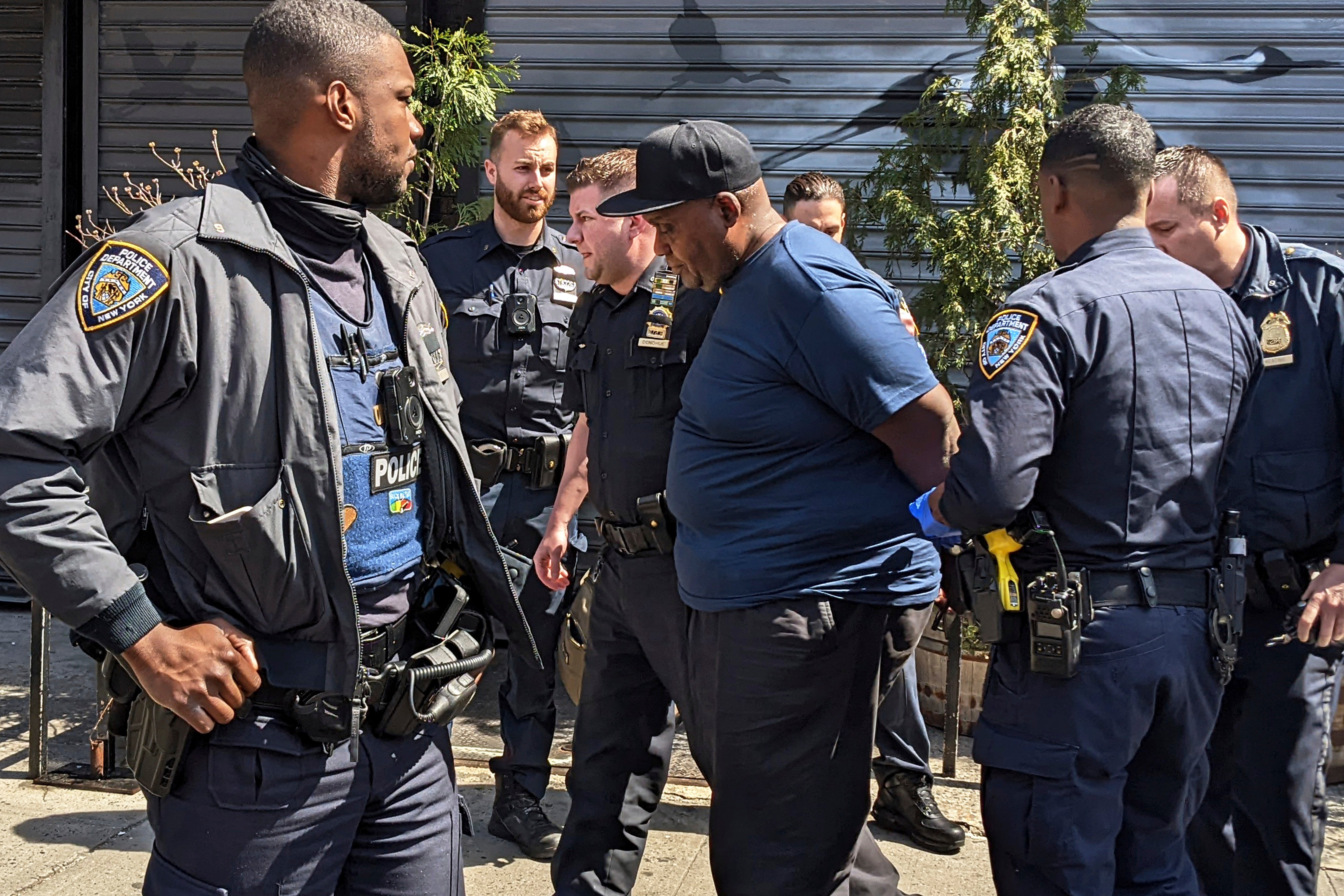 New York City Police Department officers handcuff subway shooting suspect Frank R. James in the East Village section, of New York, Wednesday, April 13, 2022