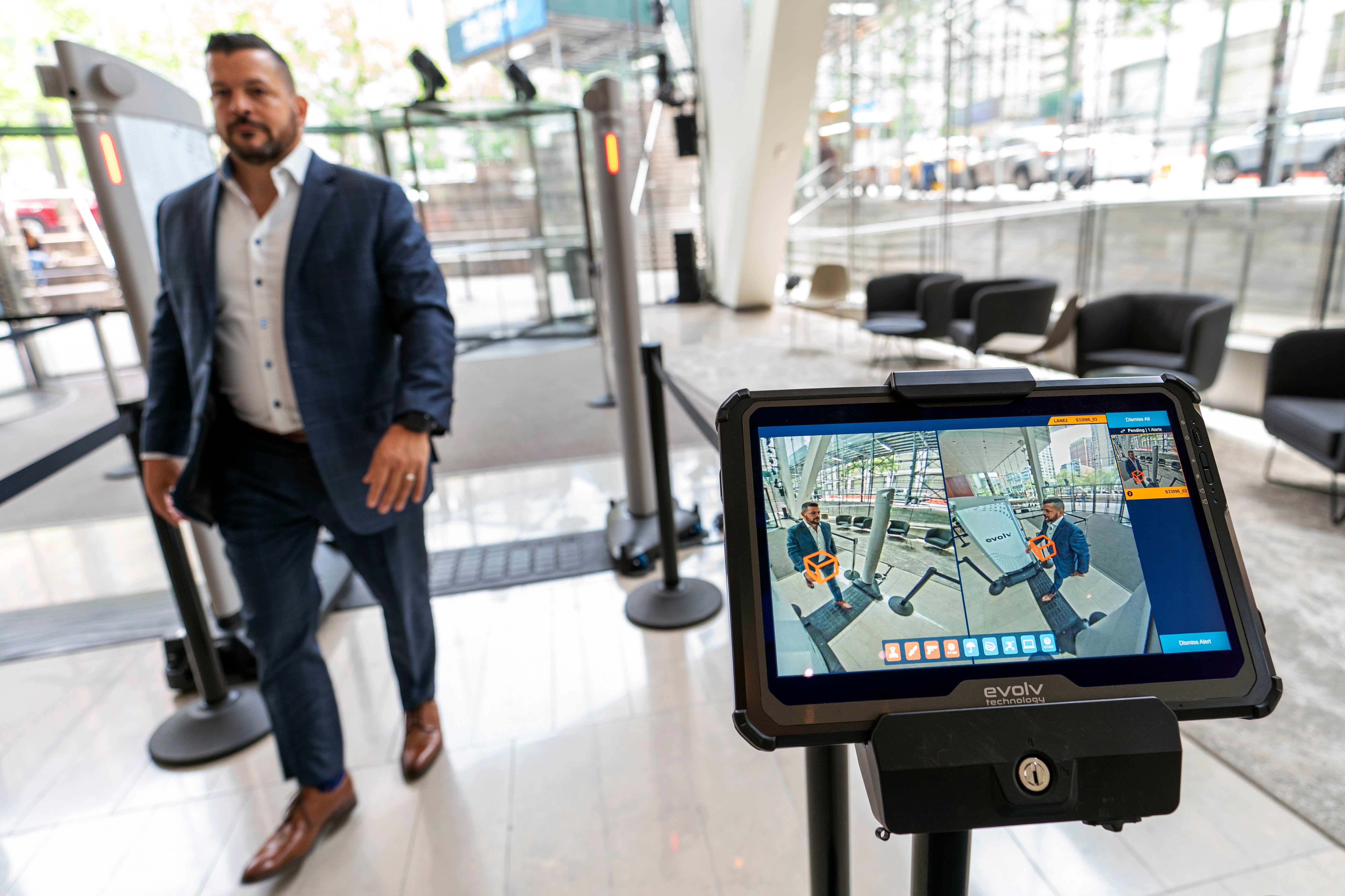 Dominck D'Orazio, account executive for Evolv Technology, demonstrates the Evolv Express weapons detection system, which is showing red lights to flag a weapon he is wearing on his hip, Wednesday, May 25, 2022, in New York