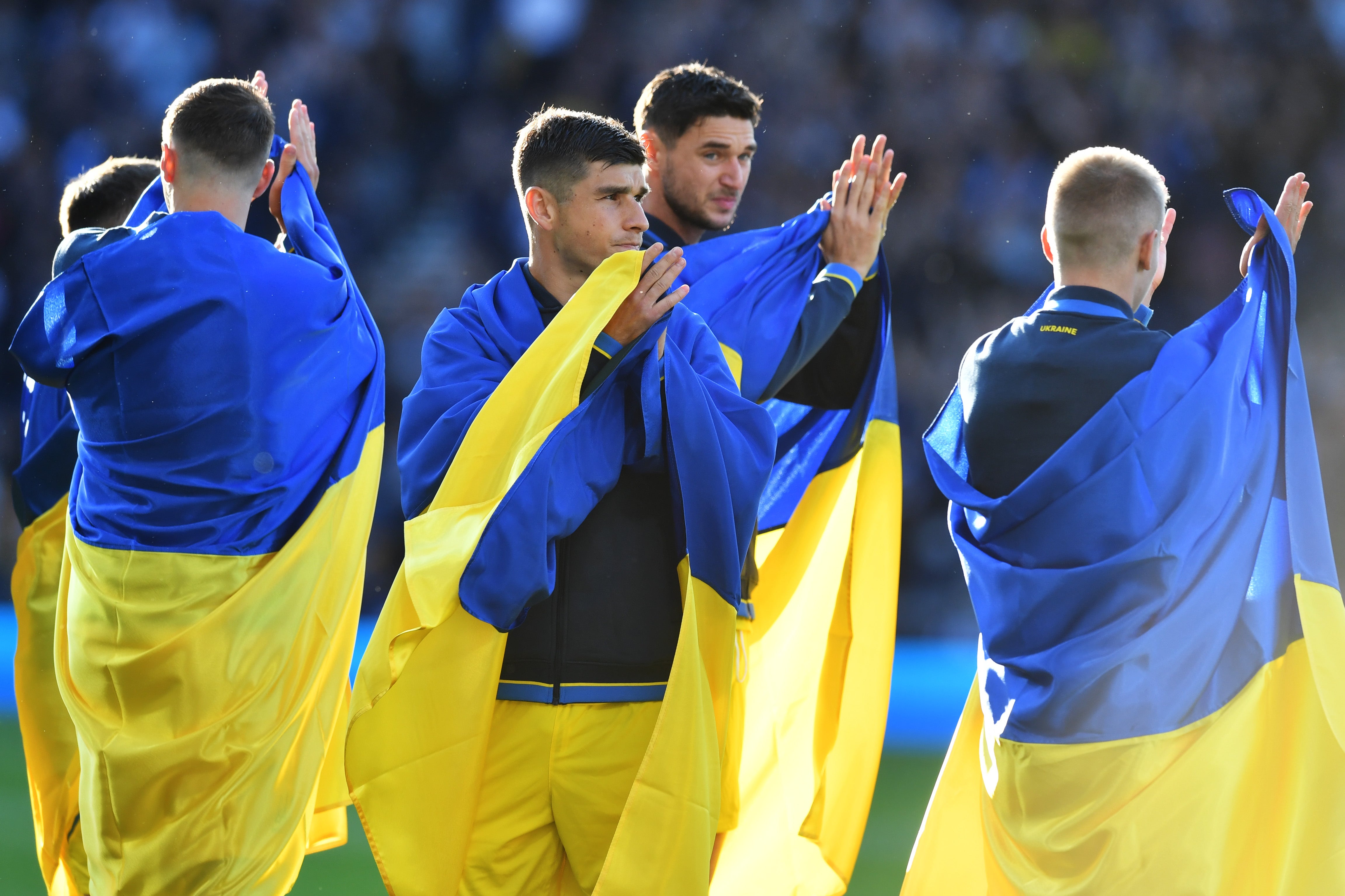 Ukraine players came out on the pitch draped in their country’s flag